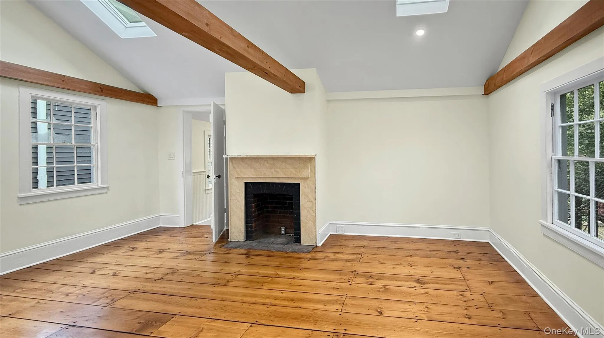 Dining room with ornamental fireplace and exposed beams. Note the beautiful floors throughout. Dining room with ornamental fireplace and exposed beams. Note the beautiful floors throughout.