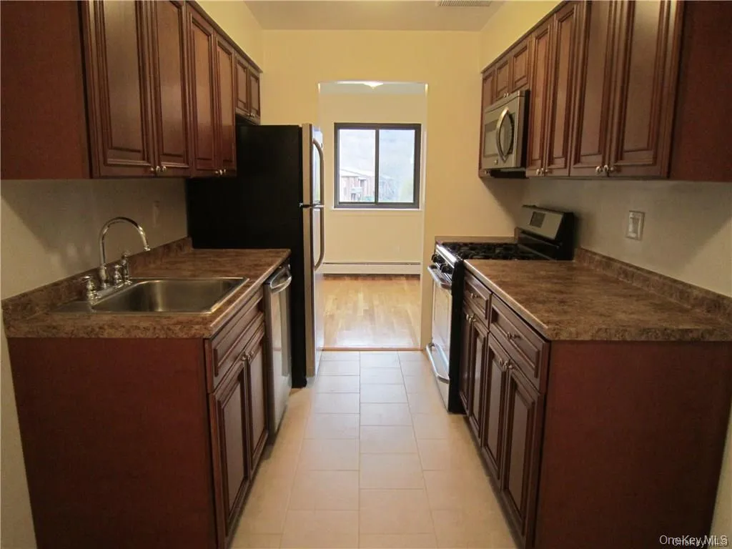 Pretty updated eat in kitchen featuring wood cabinets, stainless steel appliances and a ceramic tile floor Pretty updated eat in kitchen featuring wood cabinets, stainless steel appliances and a ceramic tile floor