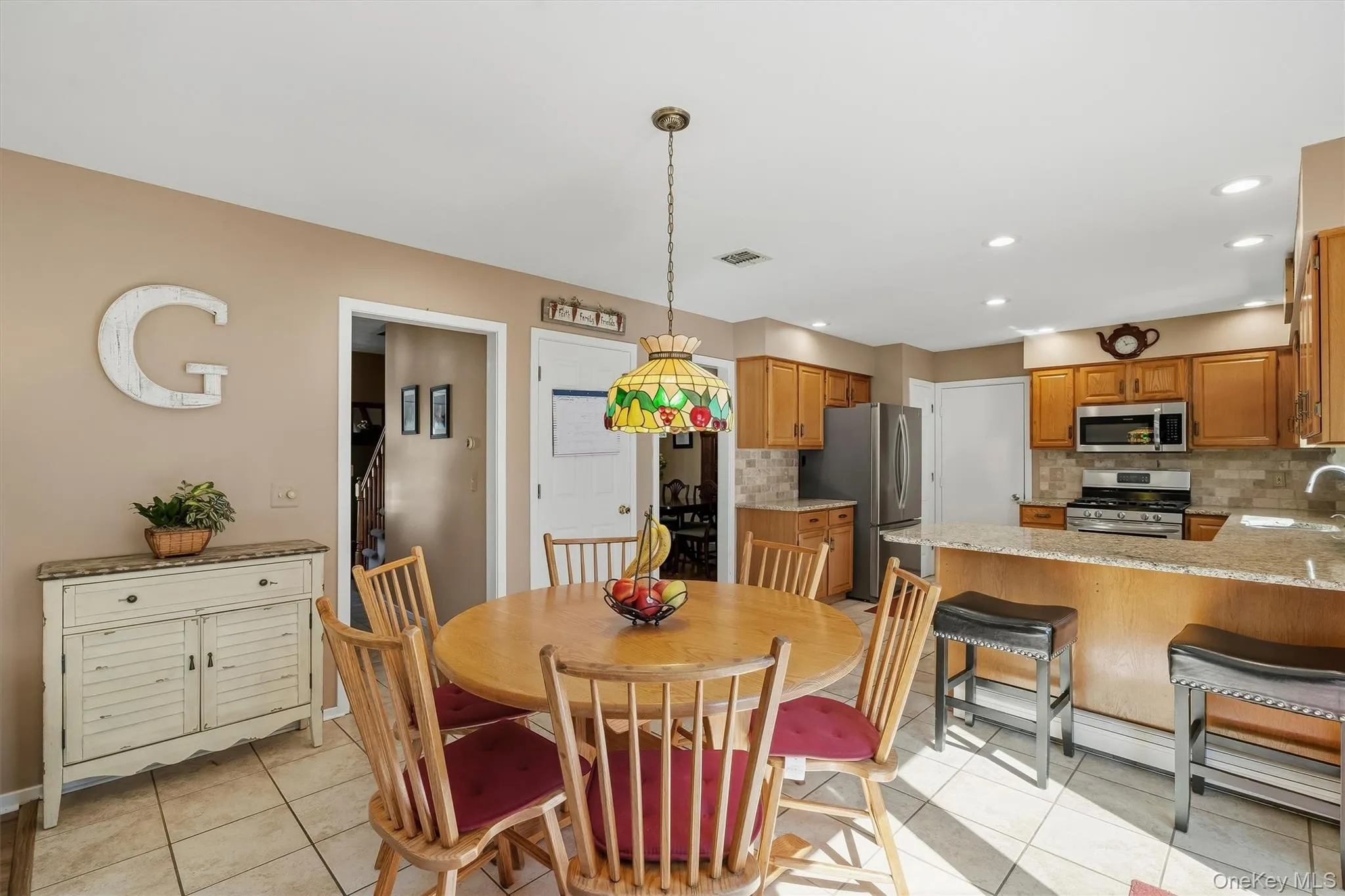 Kitchen featuring wood cabinetry, stainless steel appliances, and a tiled backsplash Kitchen featuring wood cabinetry, stainless steel appliances, and a tiled backsplash