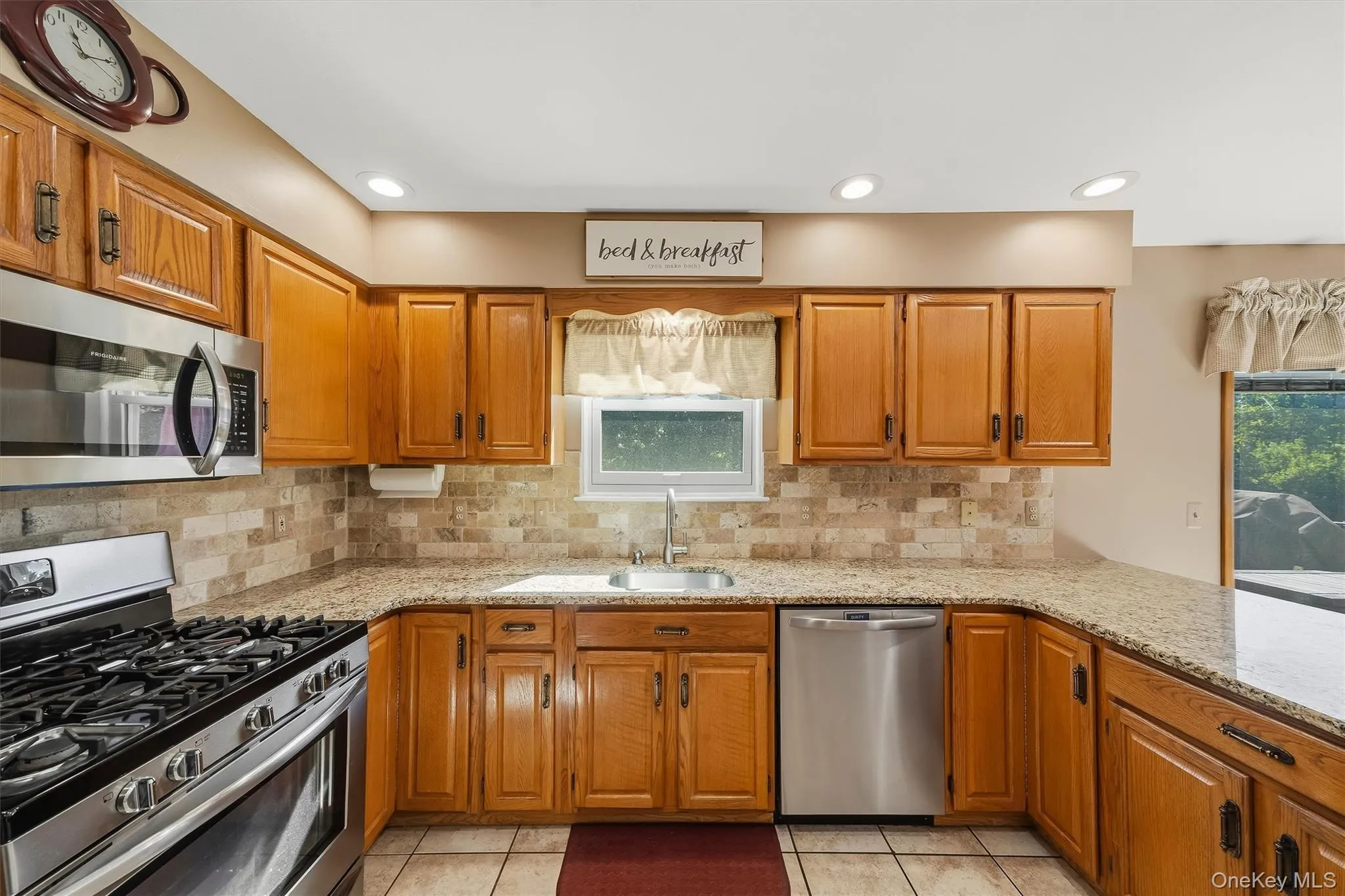 Kitchen featuring wood cabinetry, stainless steel appliances, granite-style countertops, and a tile backsplash Kitchen featuring wood cabinetry, stainless steel appliances, granite-style countertops, and a tile backsplash
