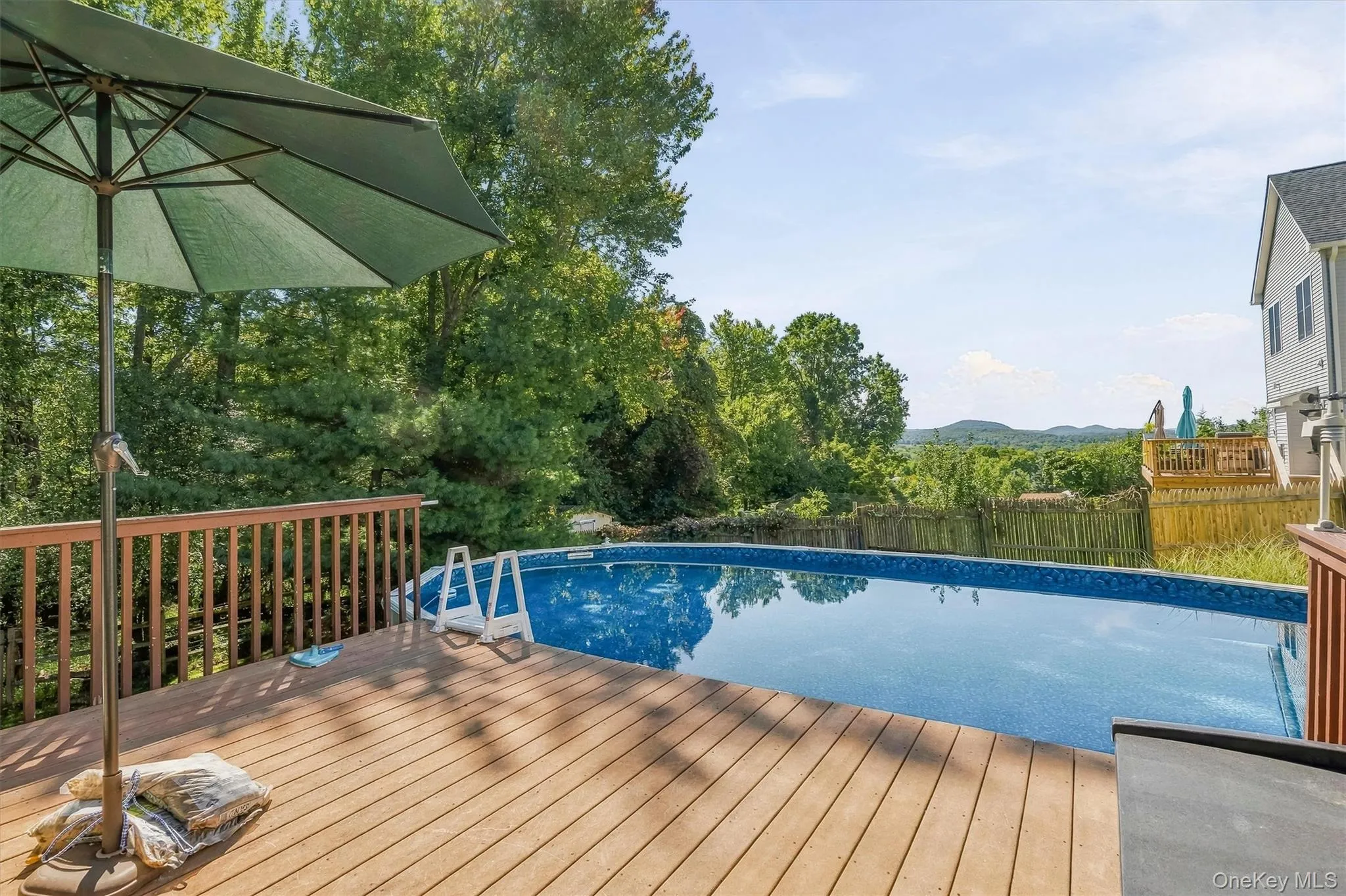 Expansive wood deck with a built-in swimming pool and wood railing Expansive wood deck with a built-in swimming pool and wood railing