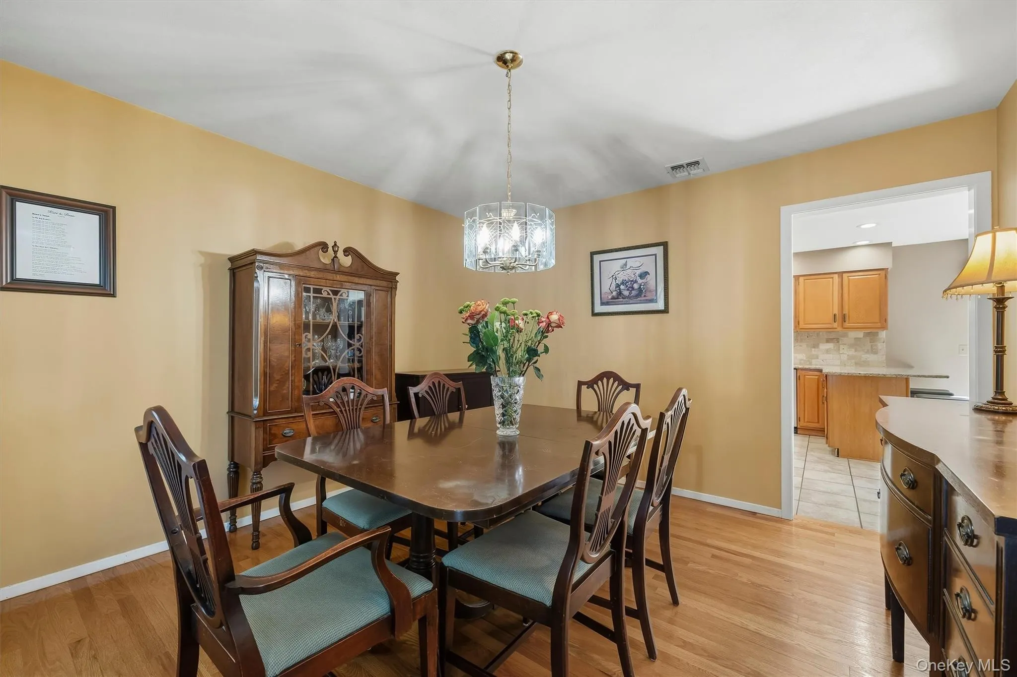 Hardwood flooring throughout featuring a decorative chandelier Hardwood flooring throughout featuring a decorative chandelier