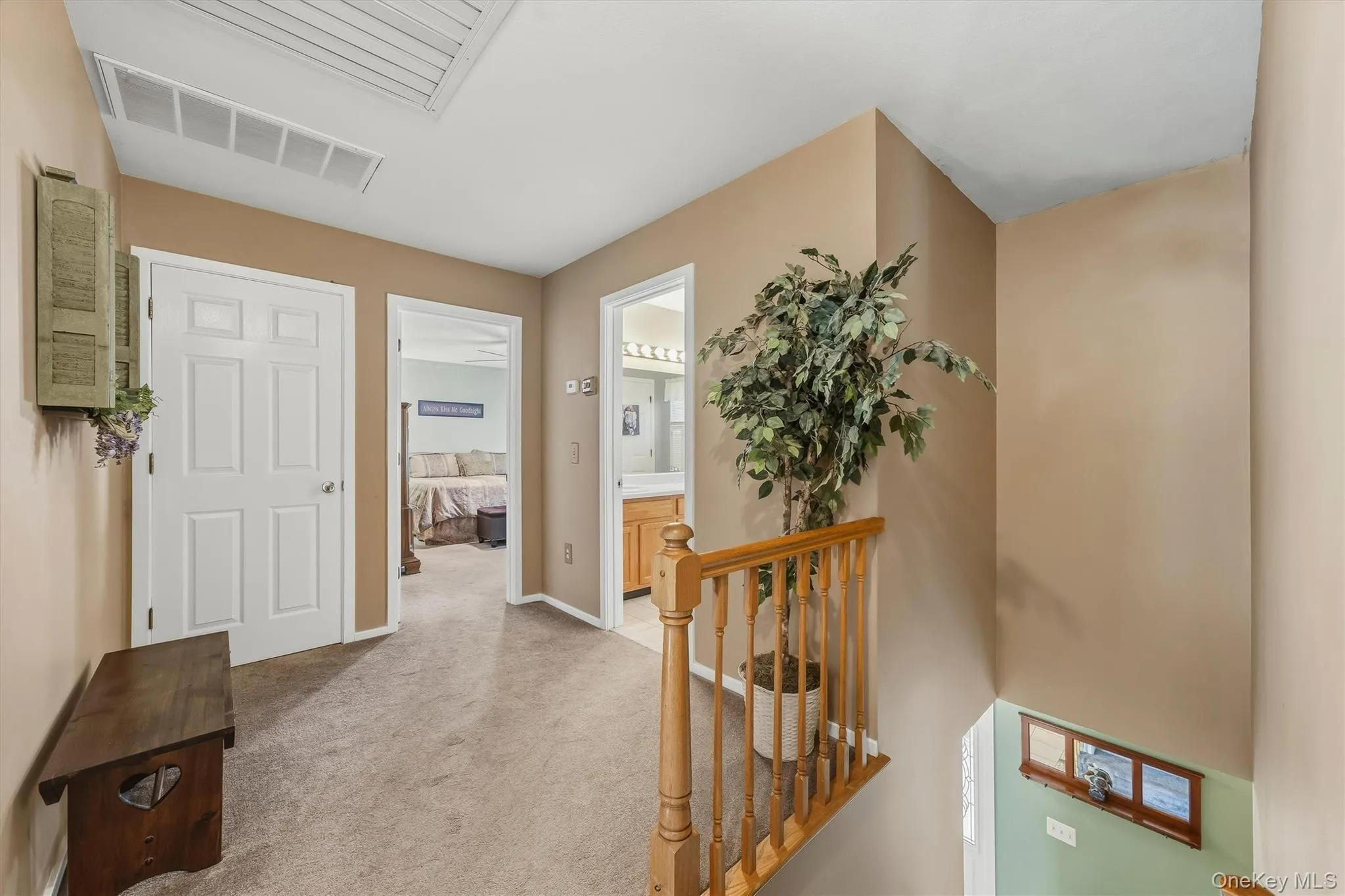 Carpeted hallway with painted walls, white doors, and a wood railing Carpeted hallway with painted walls, white doors, and a wood railing