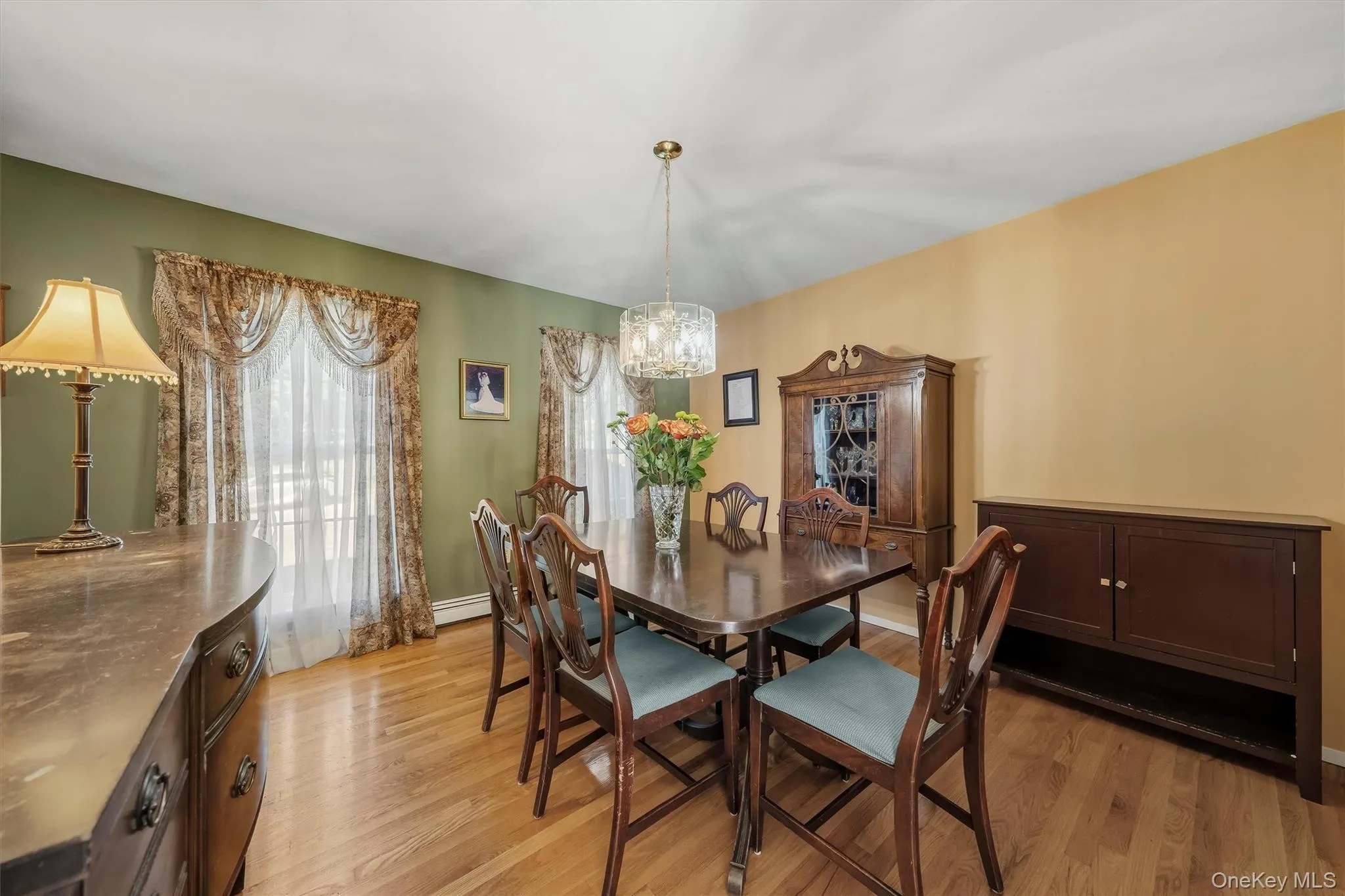 Hardwood flooring throughout, with a crystal chandelier, and large window with decorative valance Hardwood flooring throughout, with a crystal chandelier, and large window with decorative valance