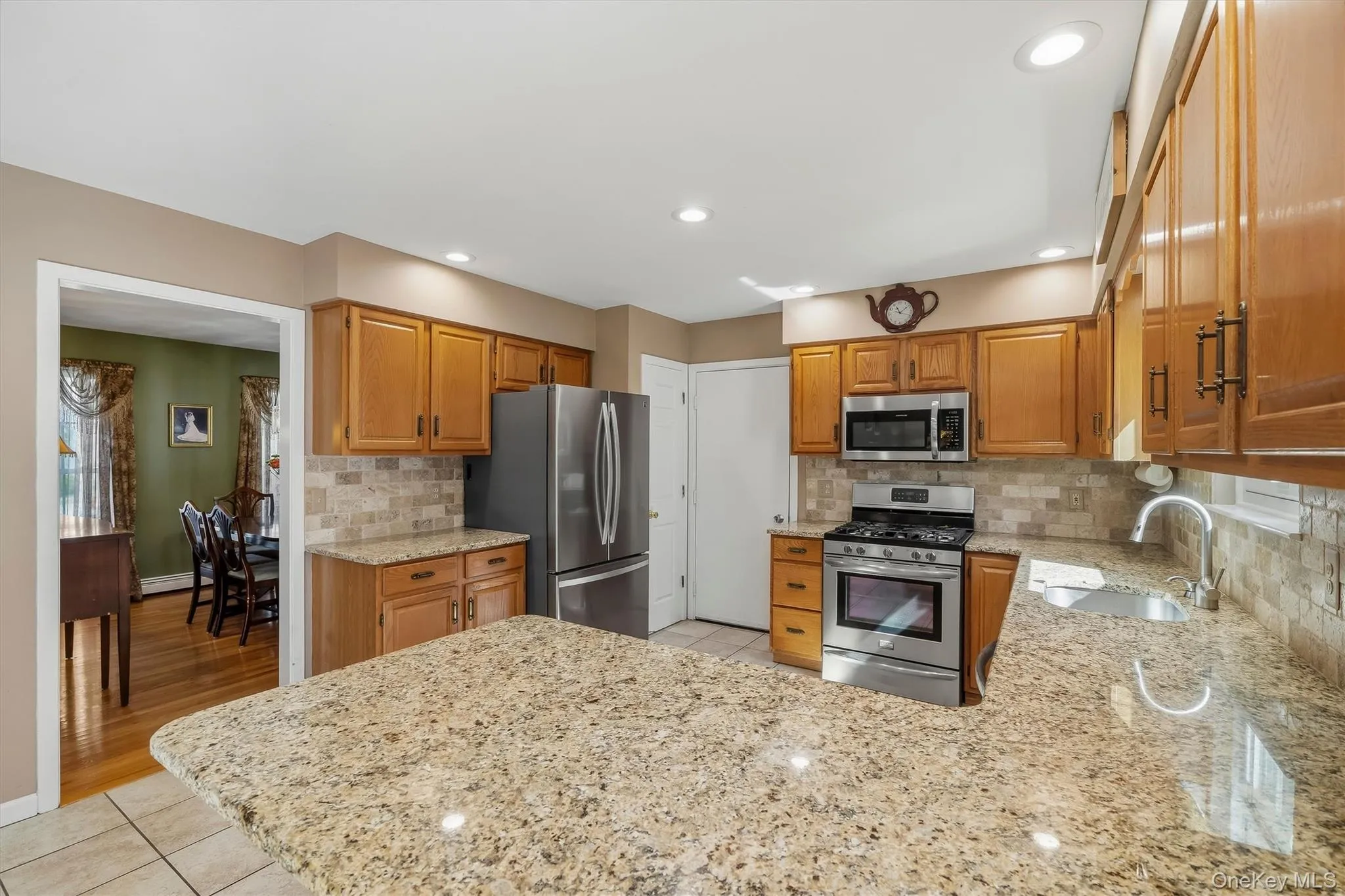 Kitchen featuring light wood cabinetry, stainless steel appliances, granite countertops, tile flooring, and recessed lighting Kitchen featuring light wood cabinetry, stainless steel appliances, granite countertops, tile flooring, and recessed lighting