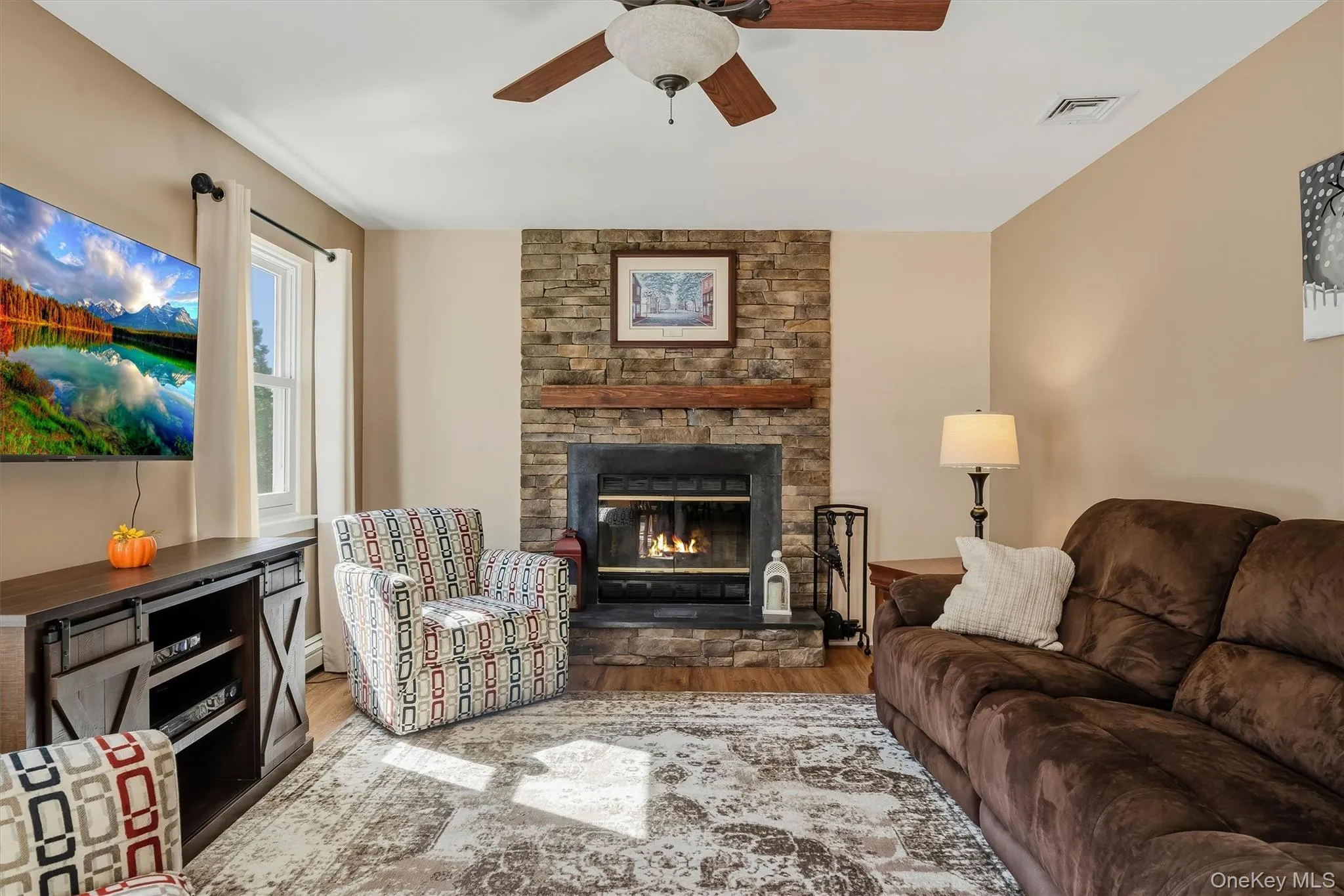 Stone fireplace featuring a wood mantel Stone fireplace featuring a wood mantel