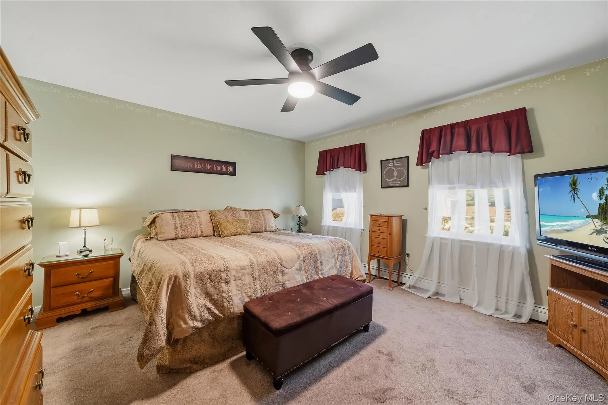 Carpeted room featuring a ceiling fan with integrated lighting, two windows, and light-toned walls Carpeted room featuring a ceiling fan with integrated lighting, two windows, and light-toned walls