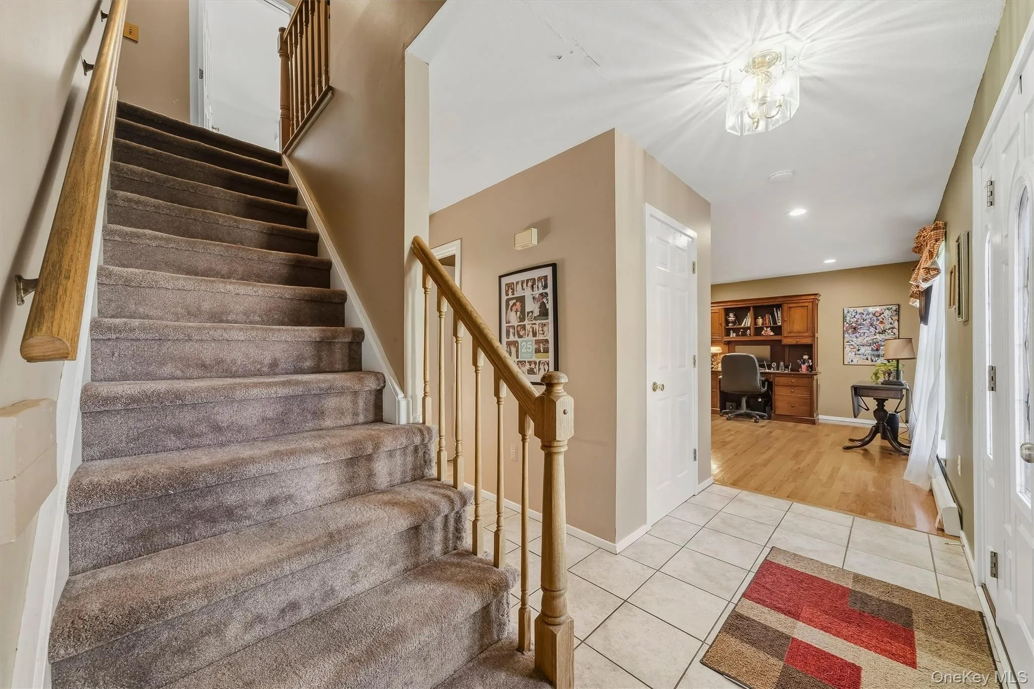Foyer featuring tile flooring, a staircase with carpet treads and a wood handrail, and recessed lighting Foyer featuring tile flooring, a staircase with carpet treads and a wood handrail, and recessed lighting