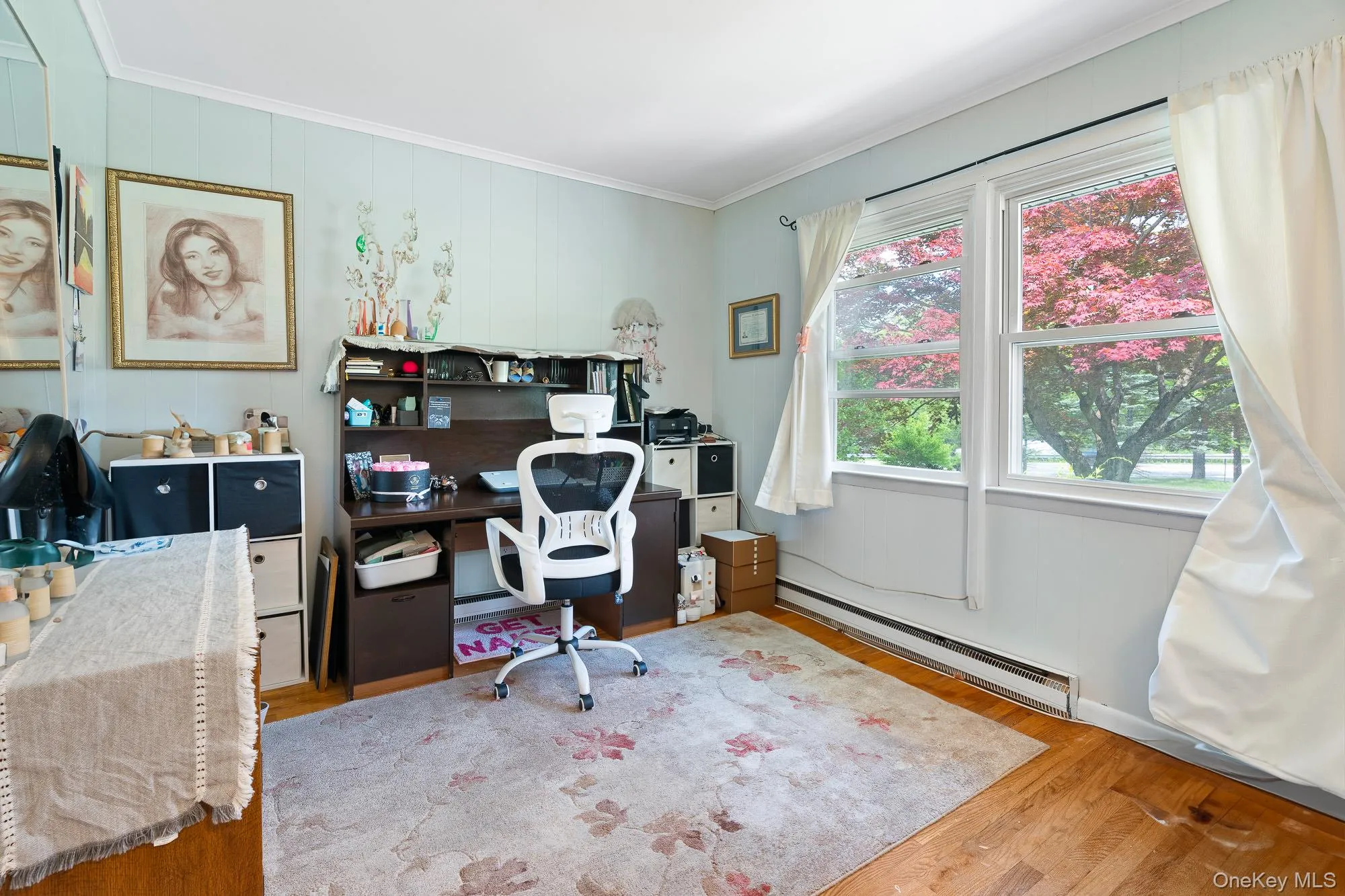 Office area with a baseboard radiator, wood finished floors, and crown molding Office area with a baseboard radiator, wood finished floors, and crown molding