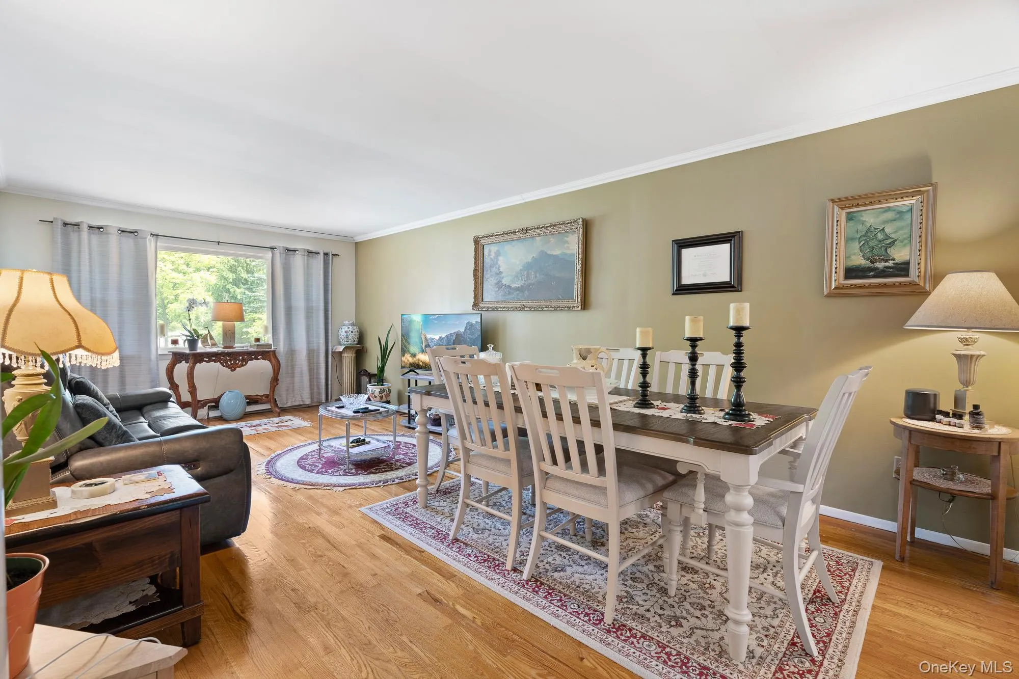 Dining room featuring wood finished floors, ornamental molding, and baseboards Dining room featuring wood finished floors, ornamental molding, and baseboards