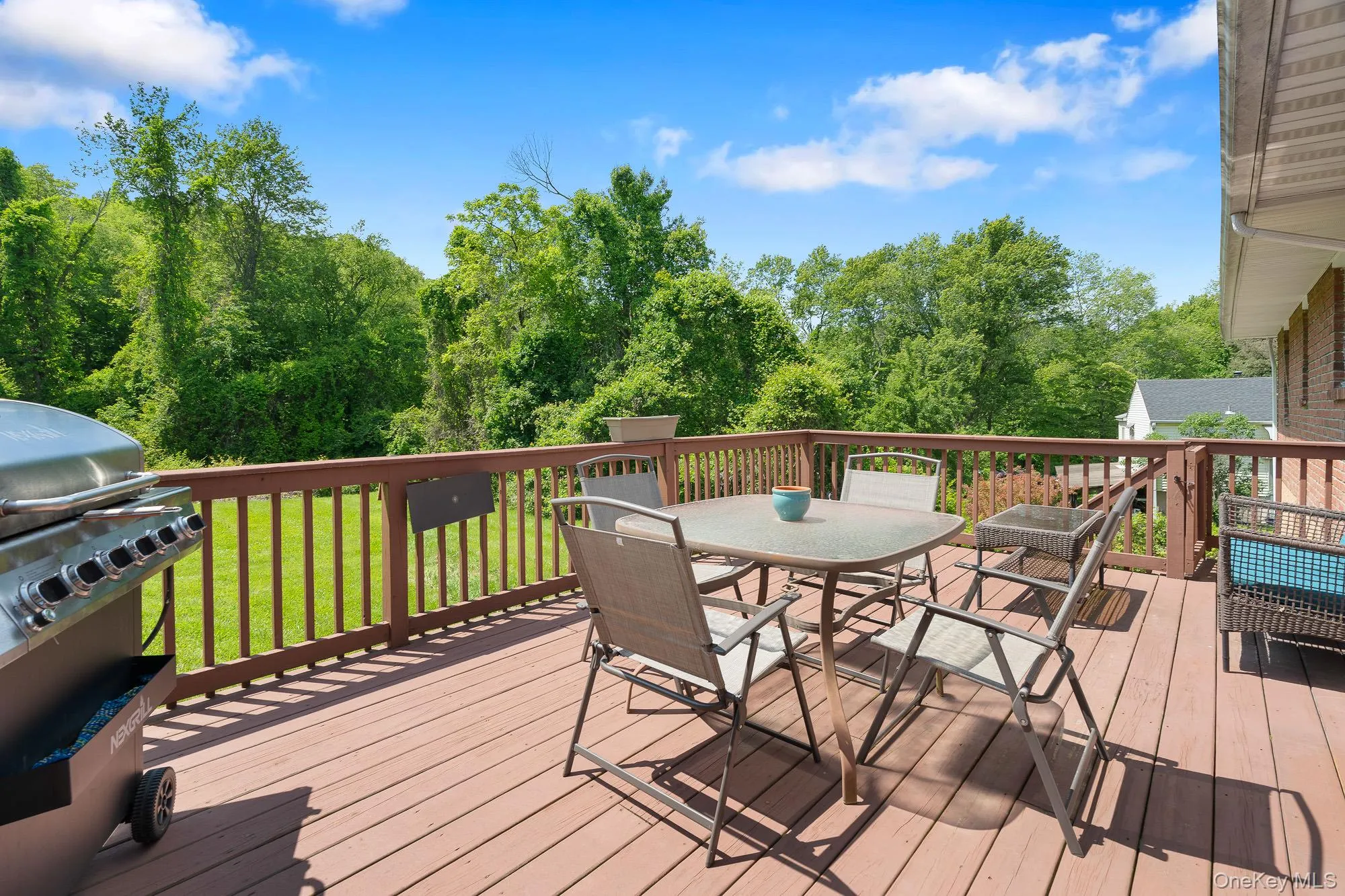 Deck with outdoor dining space, grilling area, and a yard Deck with outdoor dining space, grilling area, and a yard