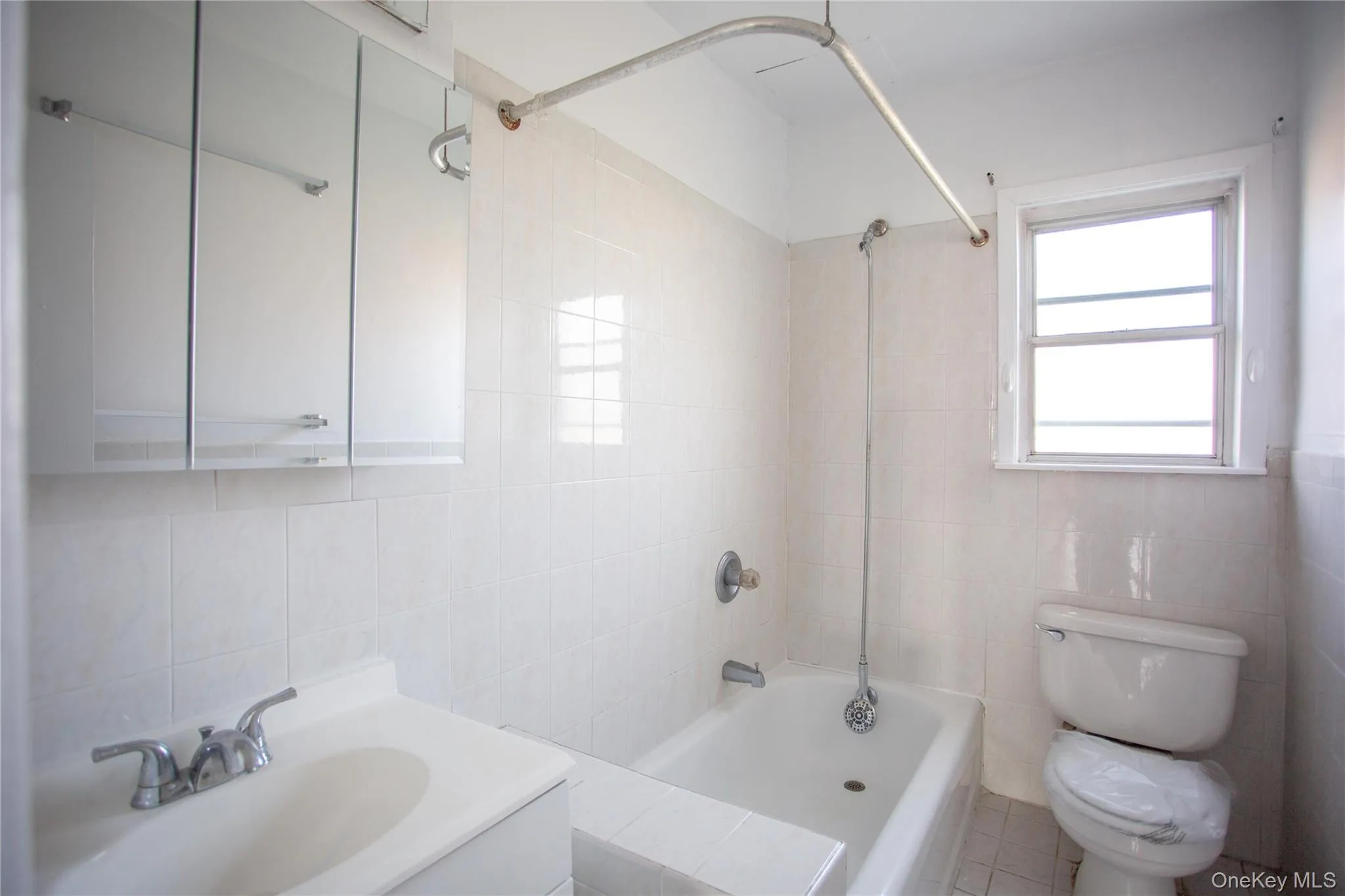 Full bathroom featuring tile walls, shower / tub combination, and vanity Full bathroom featuring tile walls, shower / tub combination, and vanity