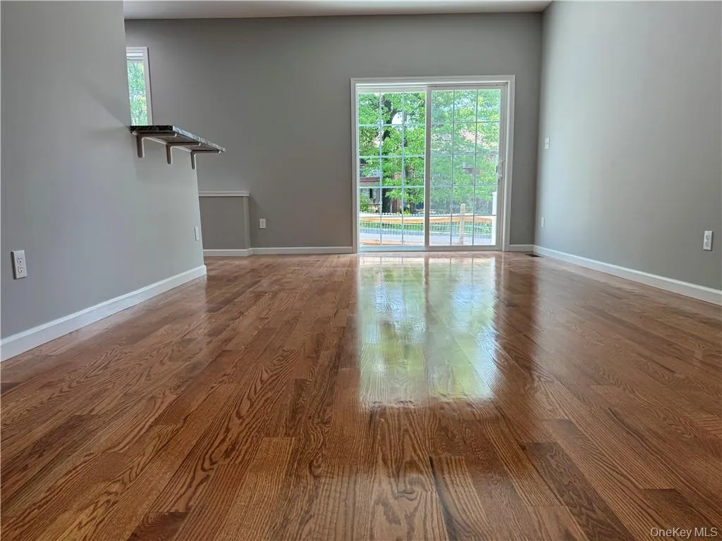 Empty room with hardwood / wood-style flooring and a healthy amount of sunlight Empty room with hardwood / wood-style flooring and a healthy amount of sunlight