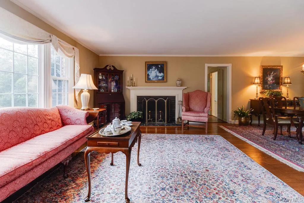 Formal living room with large picture window and elegant fireplace Formal living room with large picture window and elegant fireplace