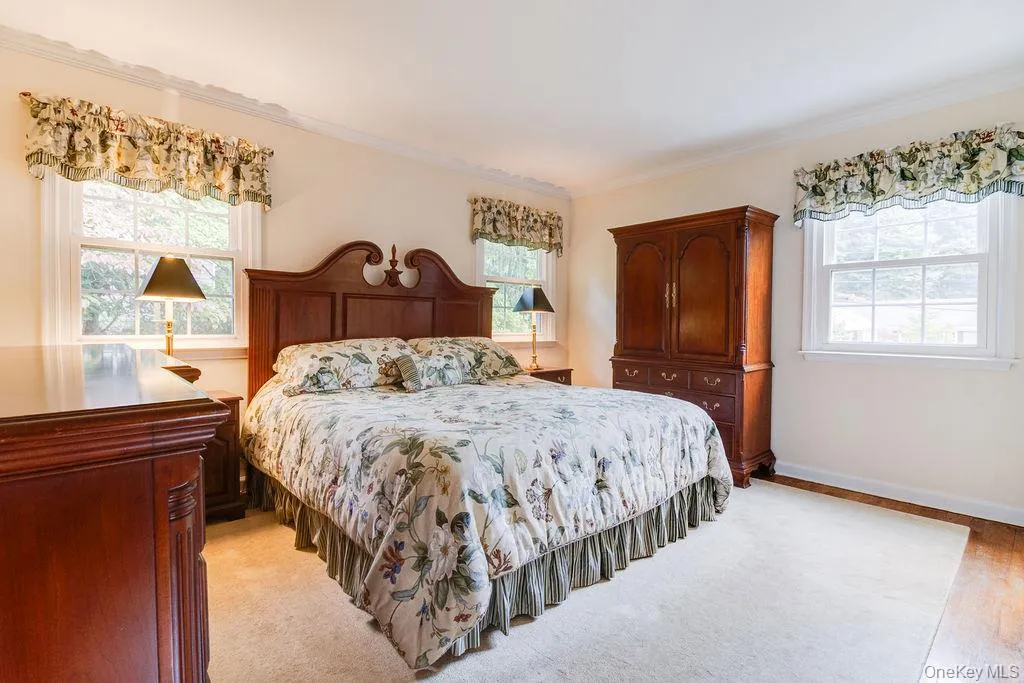 Sunny primary bedroom with hardwood floors Sunny primary bedroom with hardwood floors