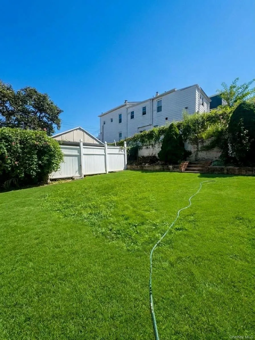 Expansive grass lawn with a white privacy fence Expansive grass lawn with a white privacy fence