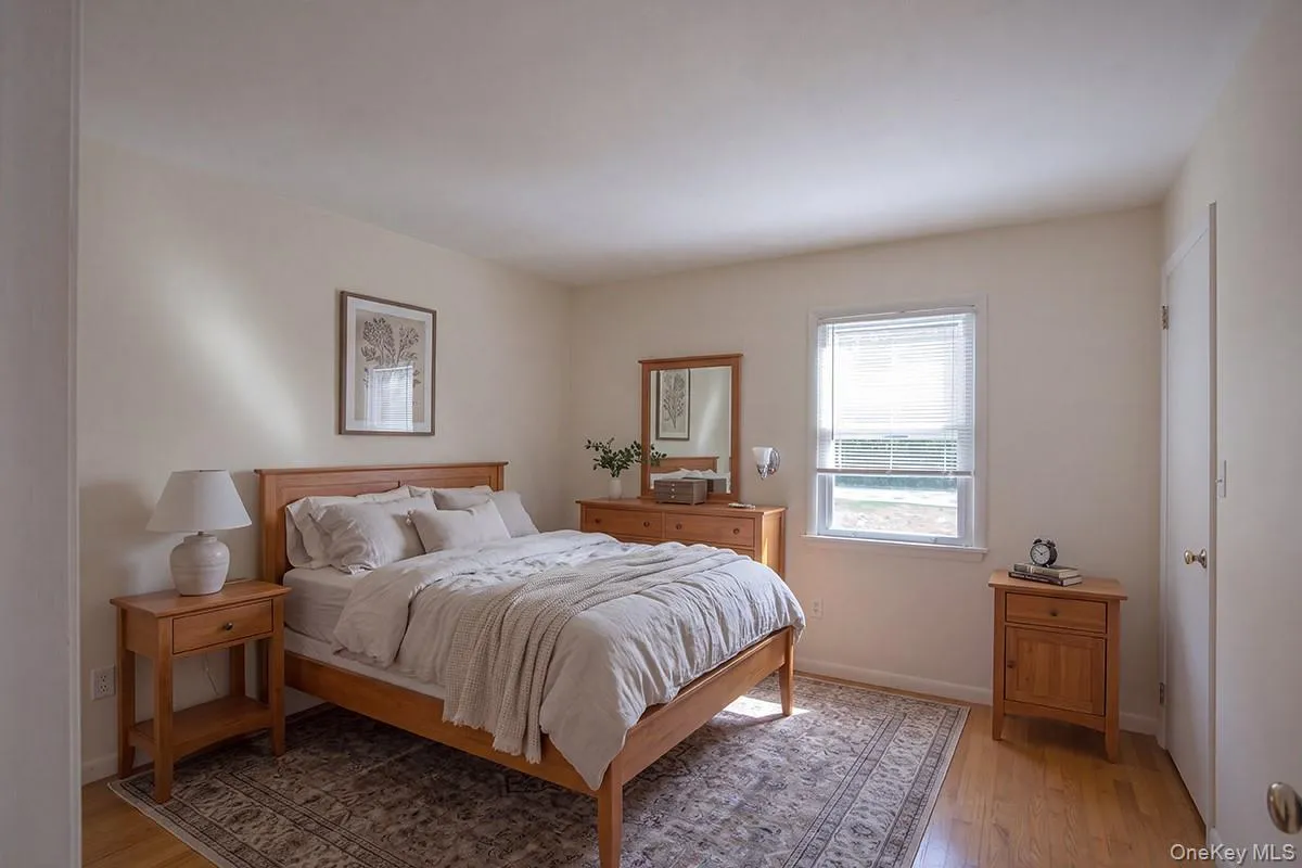 Bedroom 2-Virtually Staged; Light-toned walls, wood-finish flooring, and a single window Bedroom 2-Virtually Staged; Light-toned walls, wood-finish flooring, and a single window