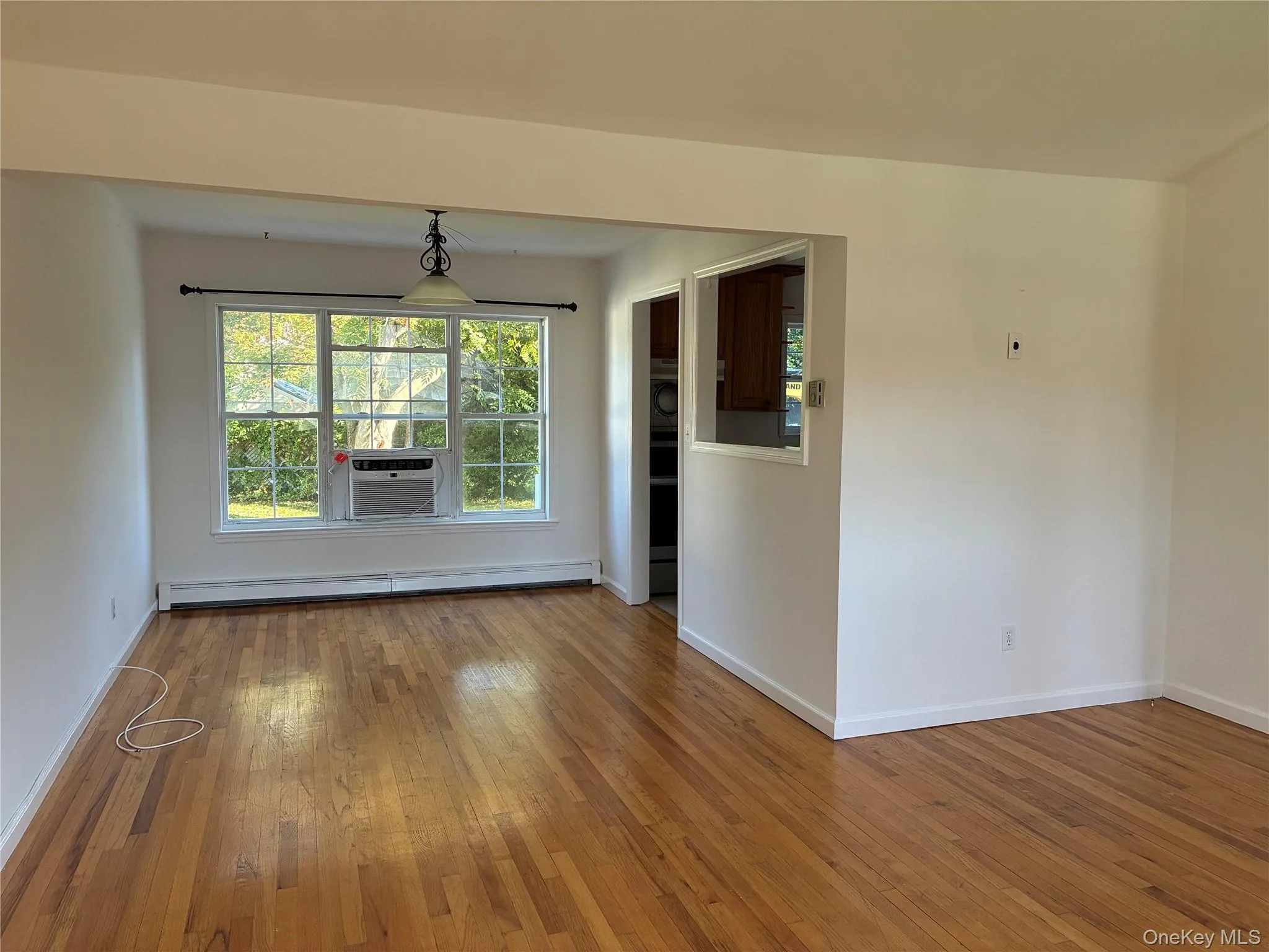 Hardwood flooring, painted white walls, recessed ceiling, chandelier, and a pass-through window Hardwood flooring, painted white walls, recessed ceiling, chandelier, and a pass-through window
