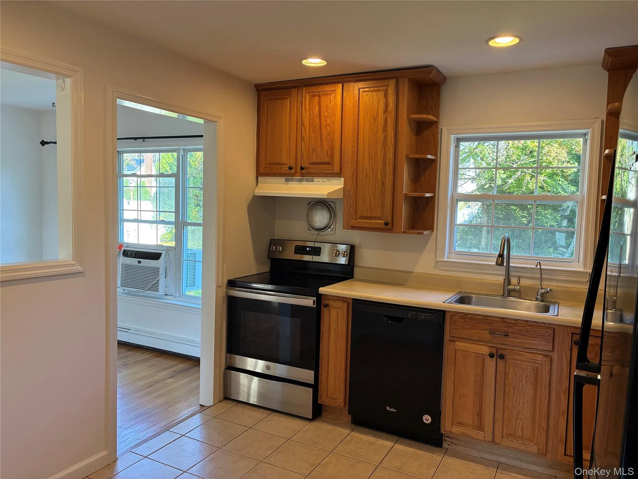 Kitchen featuring tile flooring, wood cabinetry, stainless steel range, and a built-in dishwasher Kitchen featuring tile flooring, wood cabinetry, stainless steel range, and a built-in dishwasher