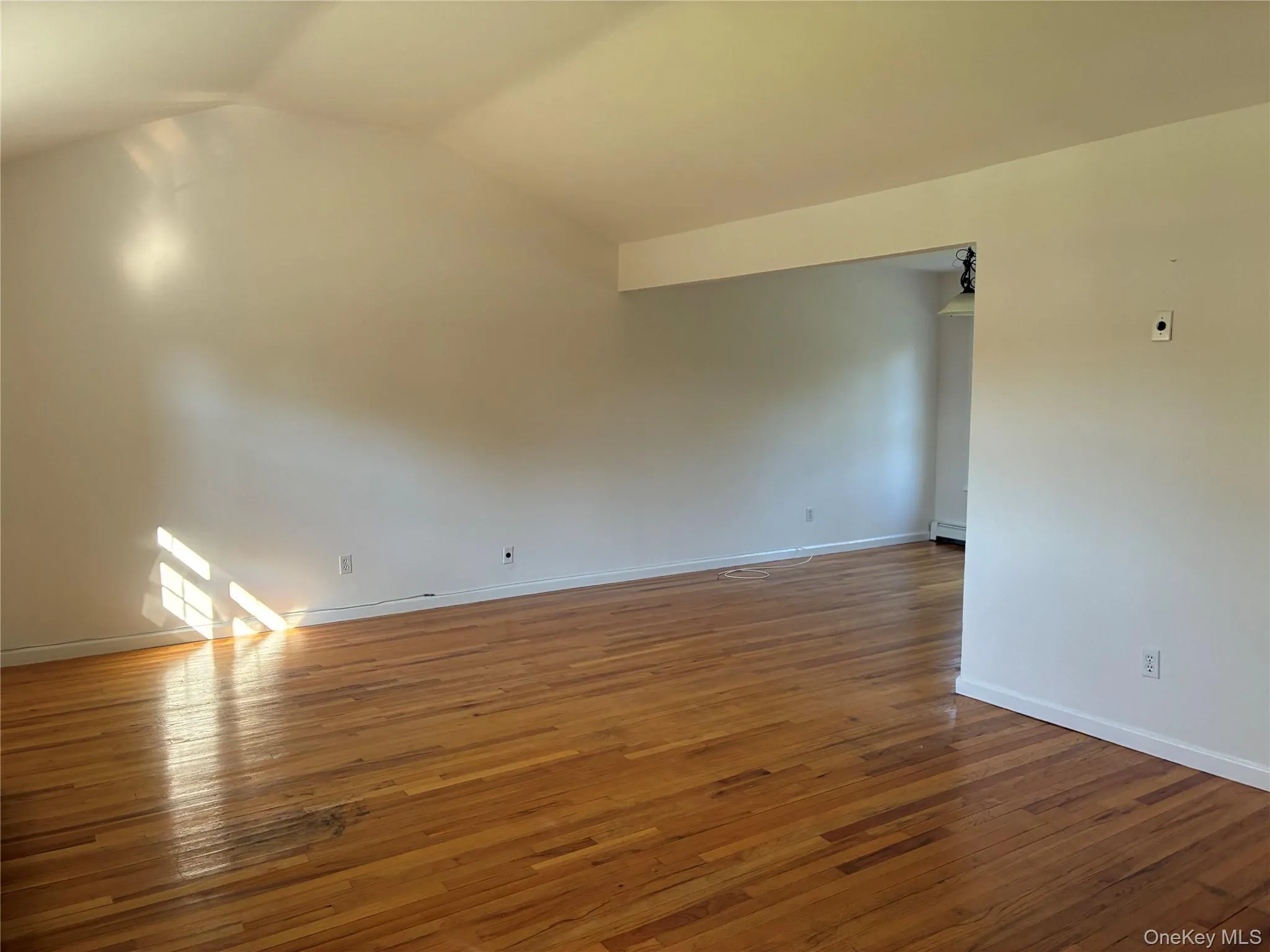 wood-finish flooring, neutral wall tones, open doorway wood-finish flooring, neutral wall tones, open doorway