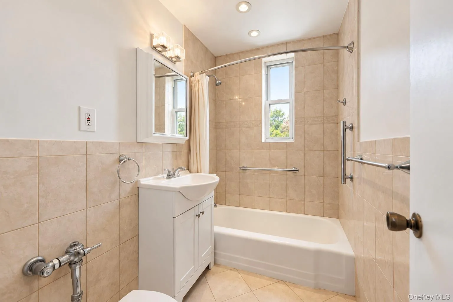 Tiled bathroom featuring a built-in tub, vanity with storage, and recessed lighting Tiled bathroom featuring a built-in tub, vanity with storage, and recessed lighting