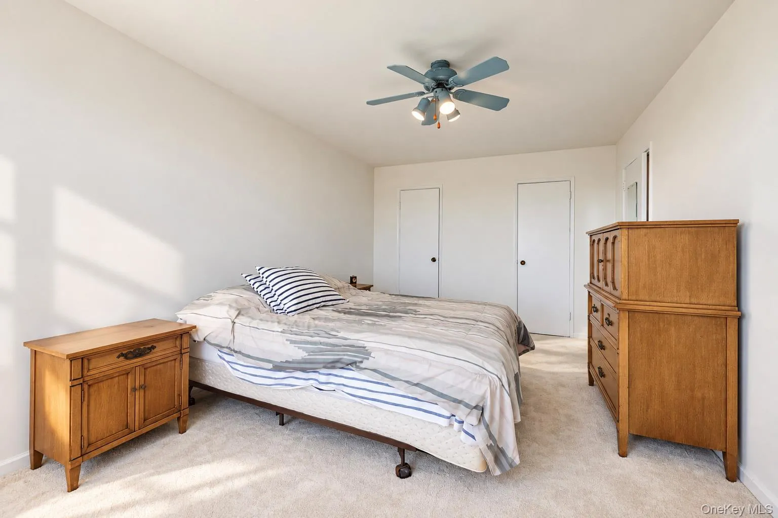 Neutral wall finishes, ceiling fan with integrated lighting, and two panel doors Neutral wall finishes, ceiling fan with integrated lighting, and two panel doors