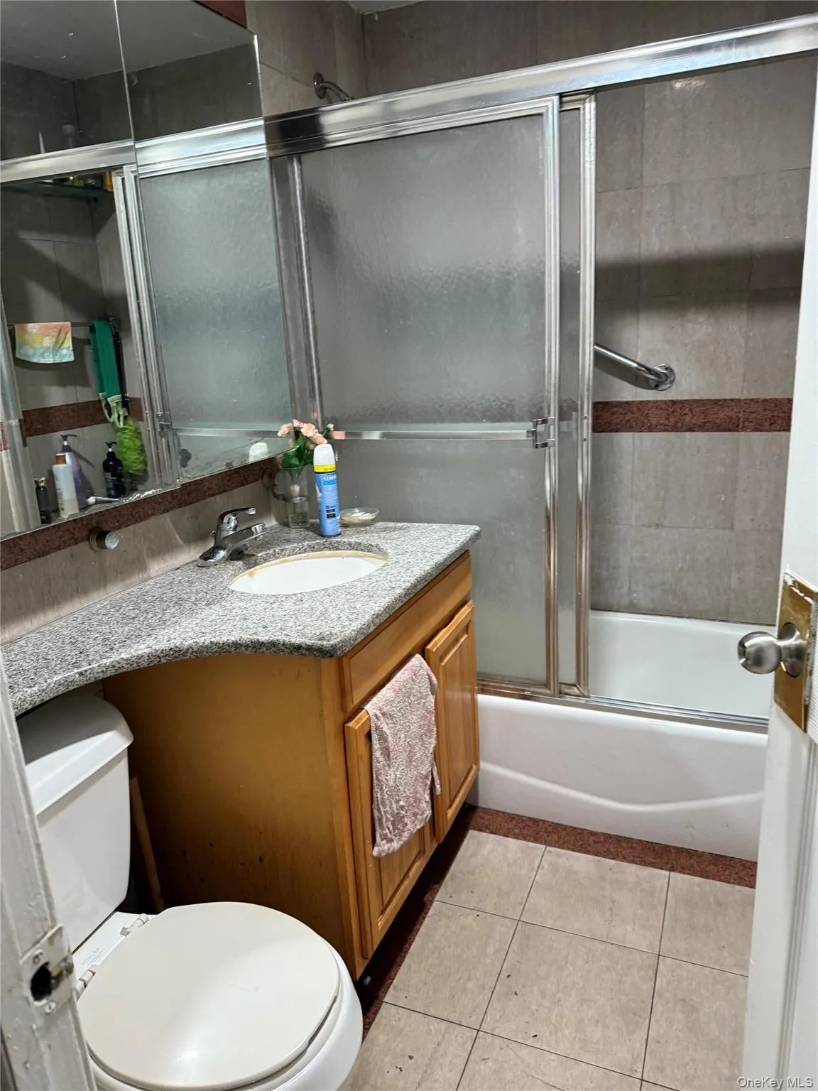 Full bath with vanity, tile patterned flooring, and enclosed tub / shower combo Full bath with vanity, tile patterned flooring, and enclosed tub / shower combo