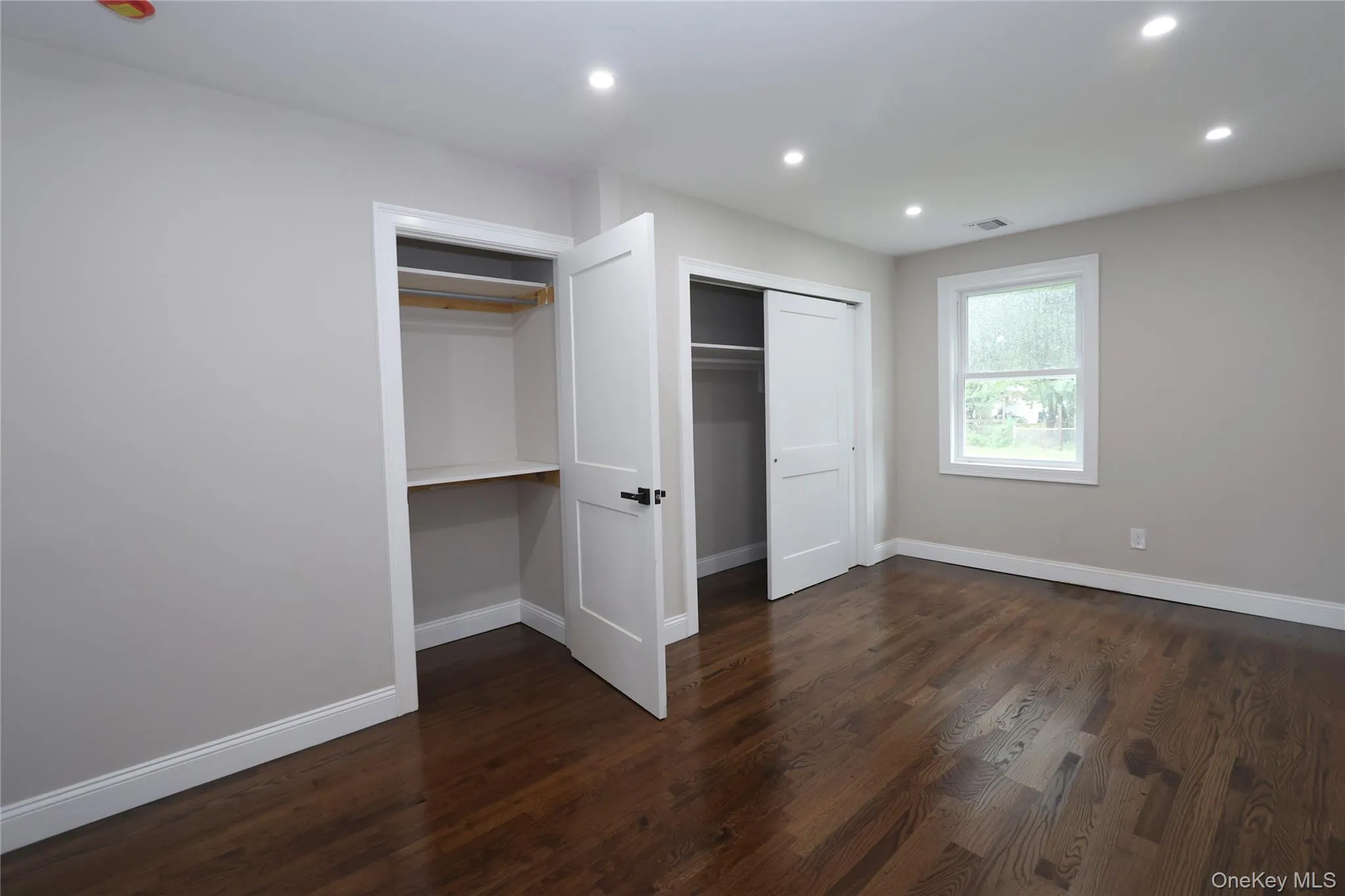 Recessed lighting, wood-finish flooring, light neutral wall paint, white trim, and a window for natural illumination Recessed lighting, wood-finish flooring, light neutral wall paint, white trim, and a window for natural illumination