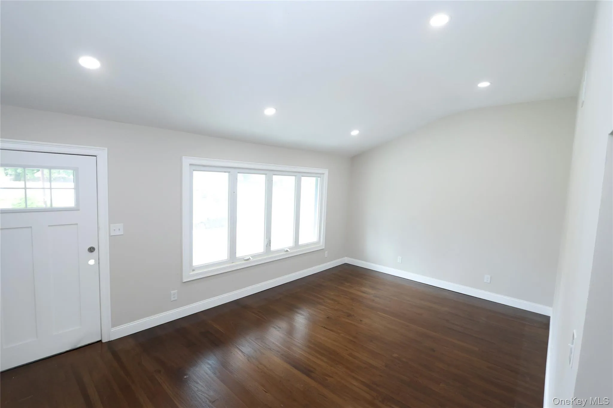Hardwood-finish flooring, recessed lighting, expansive window array, paneled entry door, and vaulted ceiling Hardwood-finish flooring, recessed lighting, expansive window array, paneled entry door, and vaulted ceiling