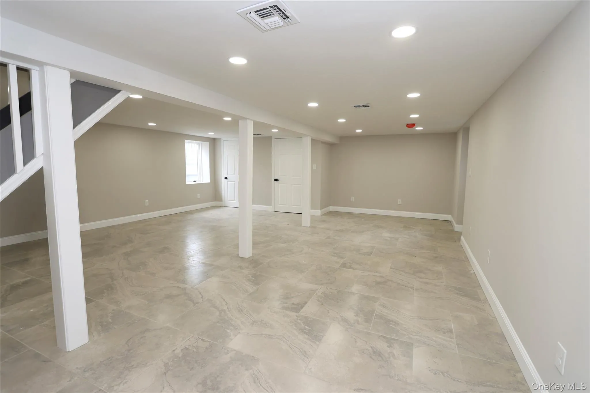 Spacious room featuring neutral wall tones, recessed lighting, and tile flooring Spacious room featuring neutral wall tones, recessed lighting, and tile flooring