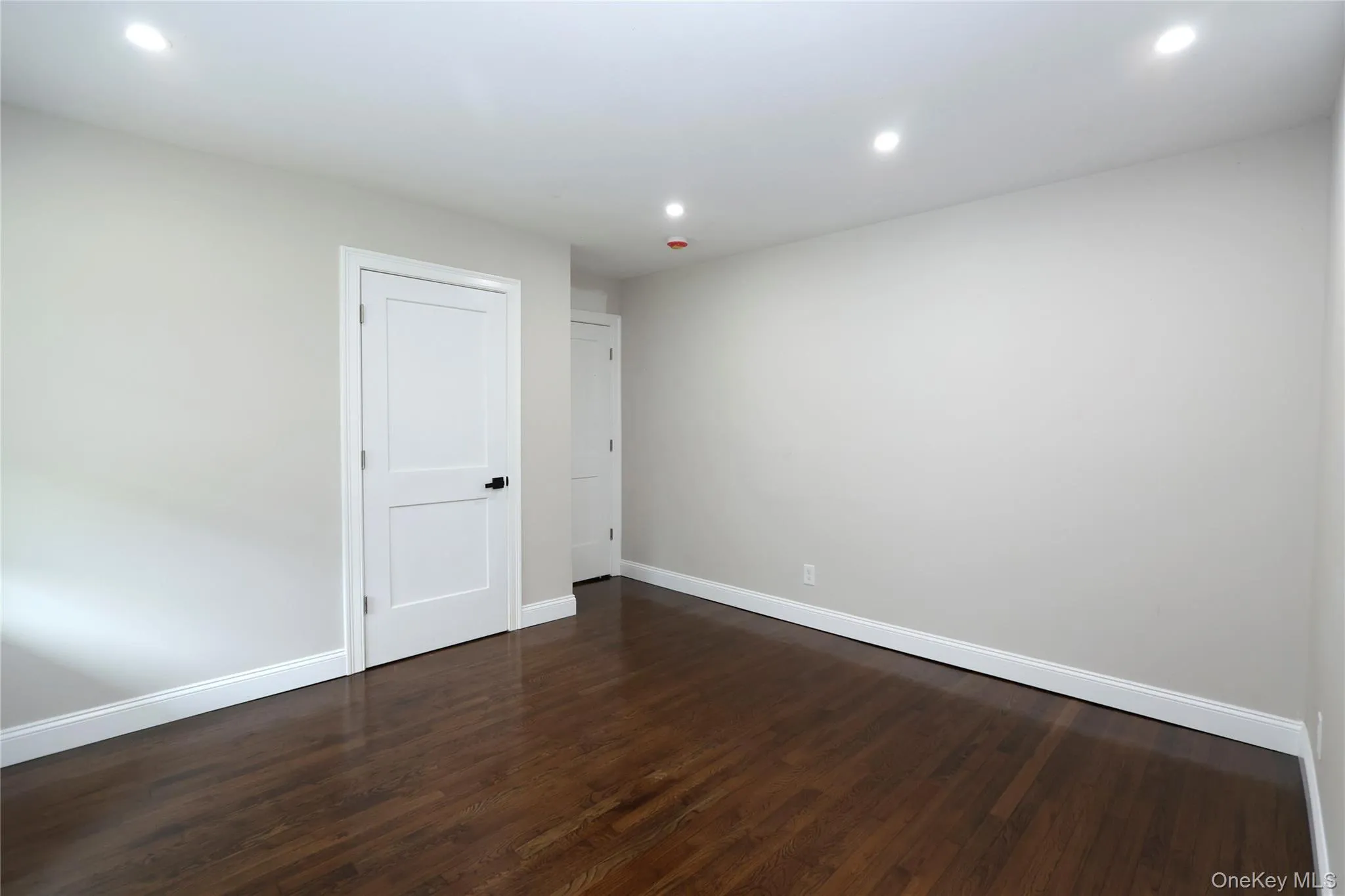 Hardwood flooring, crisp white trim, recessed lighting, and white paneled doors Hardwood flooring, crisp white trim, recessed lighting, and white paneled doors