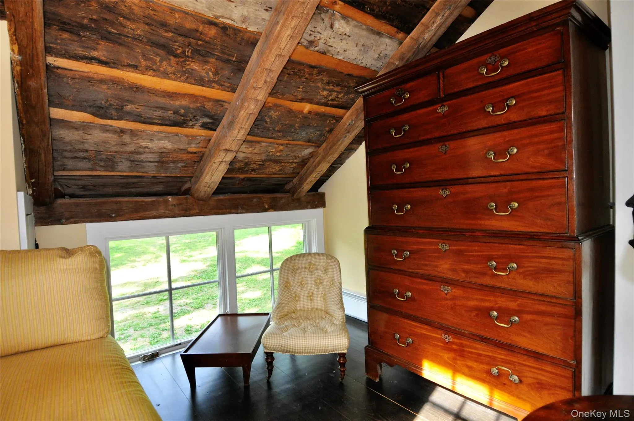 Unfurnished room featuring vaulted ceiling with beams, wood finished floors, and baseboard heating Unfurnished room featuring vaulted ceiling with beams, wood finished floors, and baseboard heating