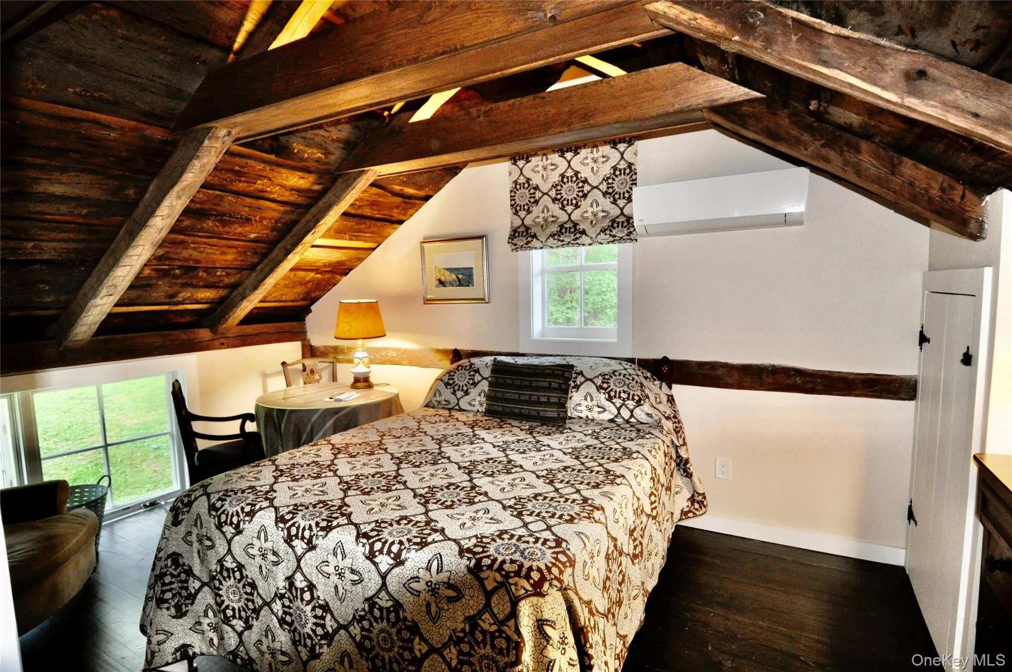 Bedroom with wooden ceiling, baseboards, a wall unit AC, wood-type flooring, and vaulted ceiling with beams Bedroom with wooden ceiling, baseboards, a wall unit AC, wood-type flooring, and vaulted ceiling with beams