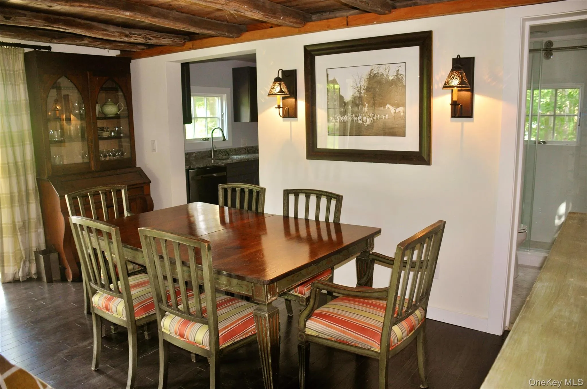 Dining room with beam ceiling, a wealth of natural light, and dark wood finished floors Dining room with beam ceiling, a wealth of natural light, and dark wood finished floors