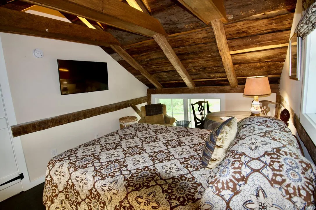 Bedroom featuring wood ceiling, lofted ceiling with beams, and a baseboard radiator Bedroom featuring wood ceiling, lofted ceiling with beams, and a baseboard radiator