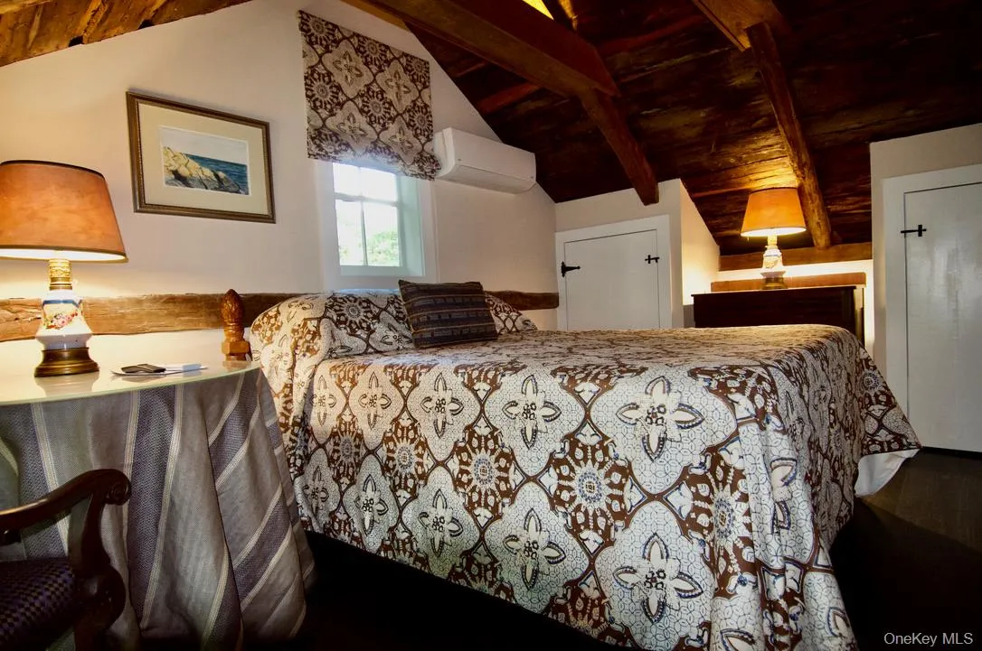 Bedroom with wooden ceiling, a wall mounted air conditioner, and lofted ceiling with beams Bedroom with wooden ceiling, a wall mounted air conditioner, and lofted ceiling with beams
