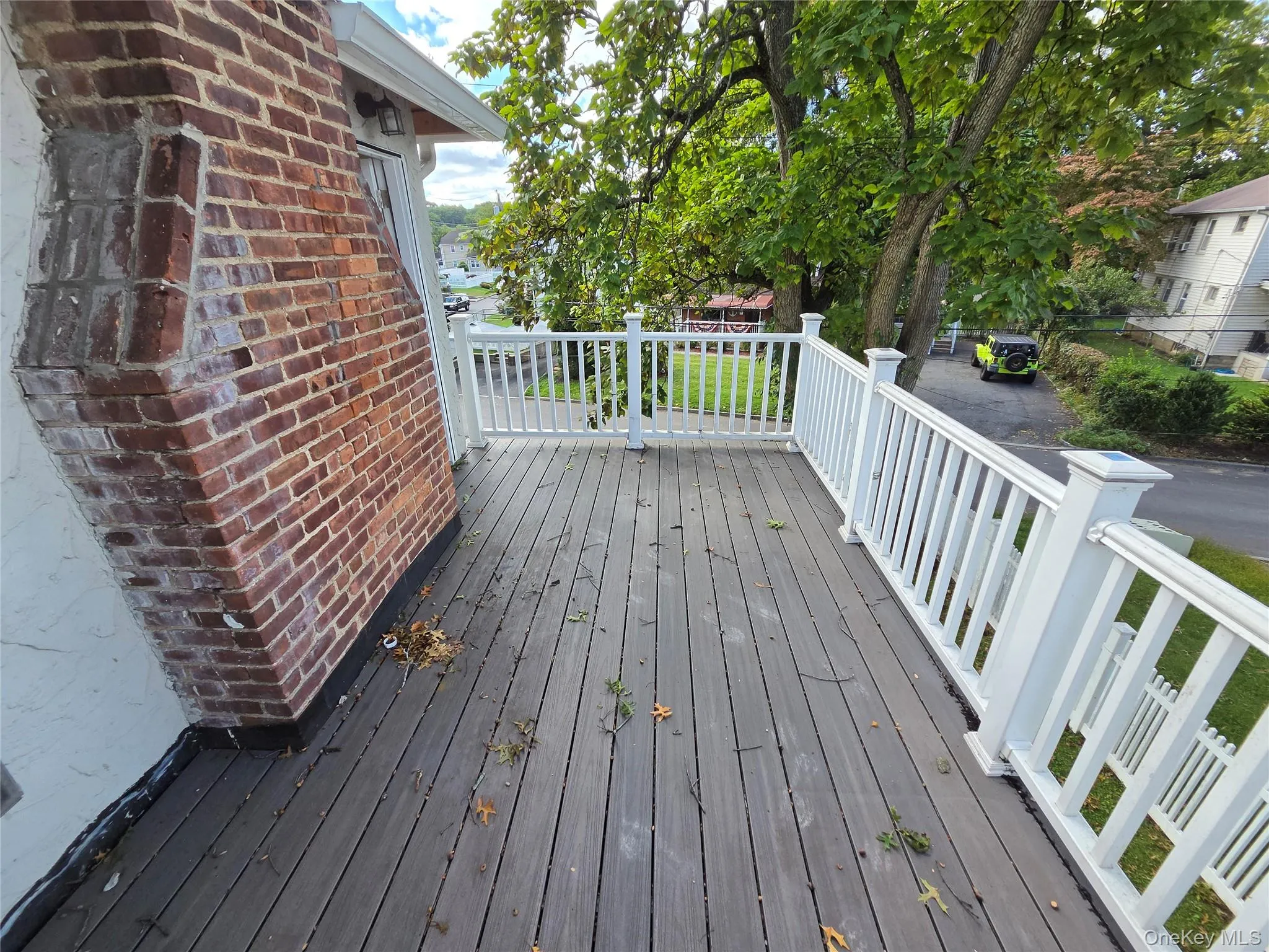 Deck with composite decking, white railings, and a brick chimney Deck with composite decking, white railings, and a brick chimney