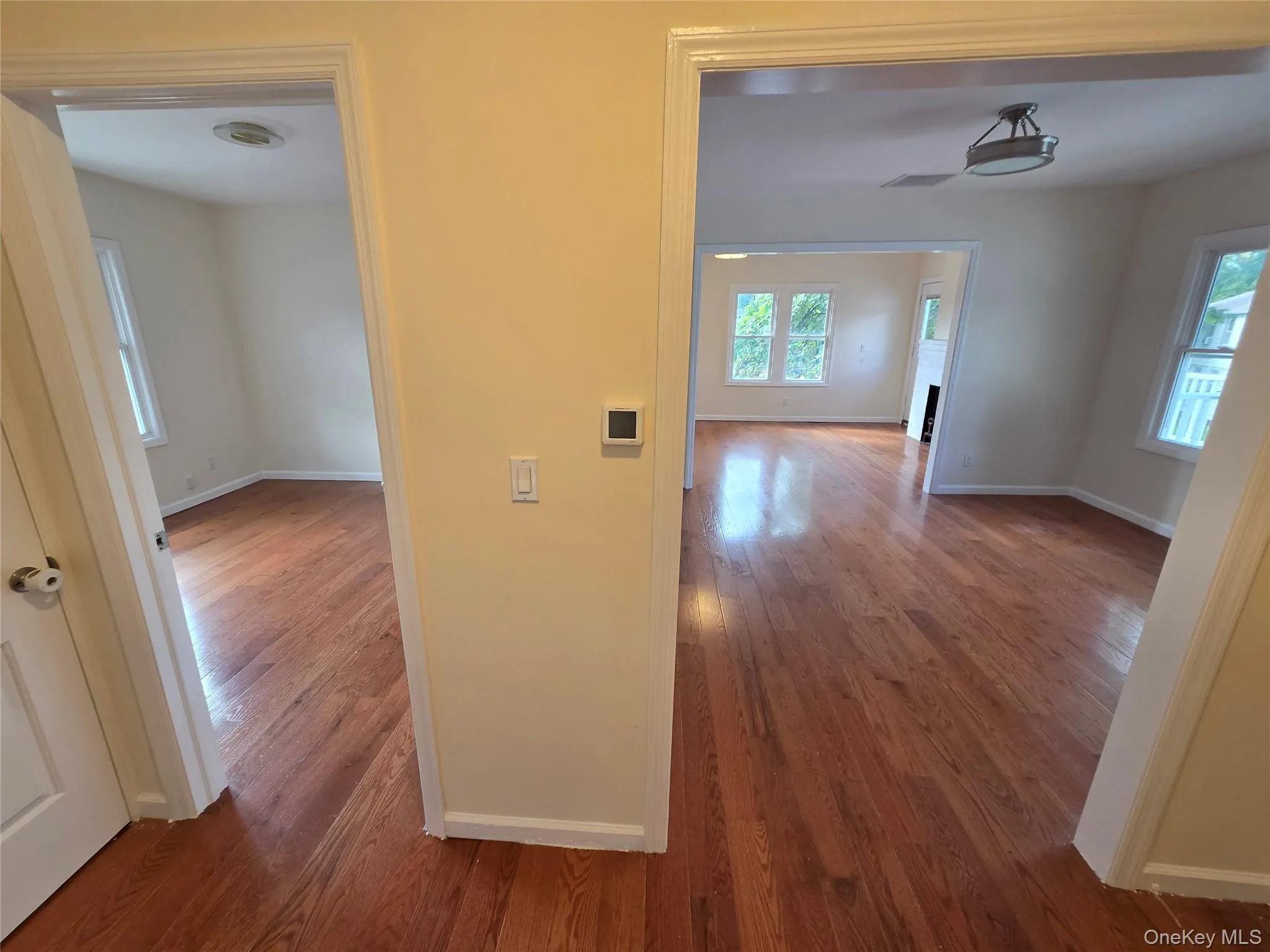 Hardwood flooring throughout, neutral wall tones, recessed ceiling lighting, and a drum-style ceiling fixture Hardwood flooring throughout, neutral wall tones, recessed ceiling lighting, and a drum-style ceiling fixture