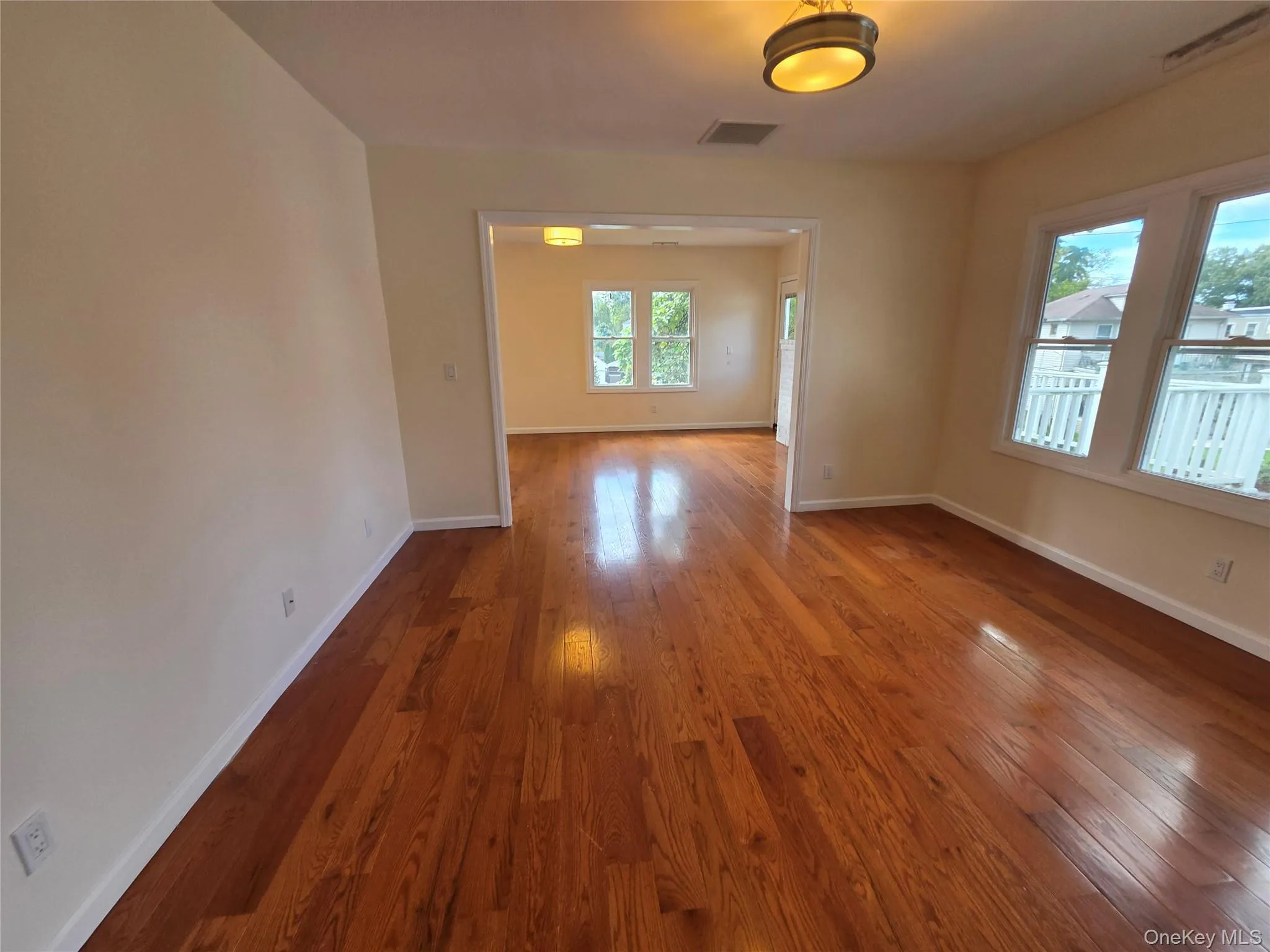 Rich wood-finish flooring, neutral wall tones, white trim, recessed lighting, and a drum-style ceiling fixture Rich wood-finish flooring, neutral wall tones, white trim, recessed lighting, and a drum-style ceiling fixture