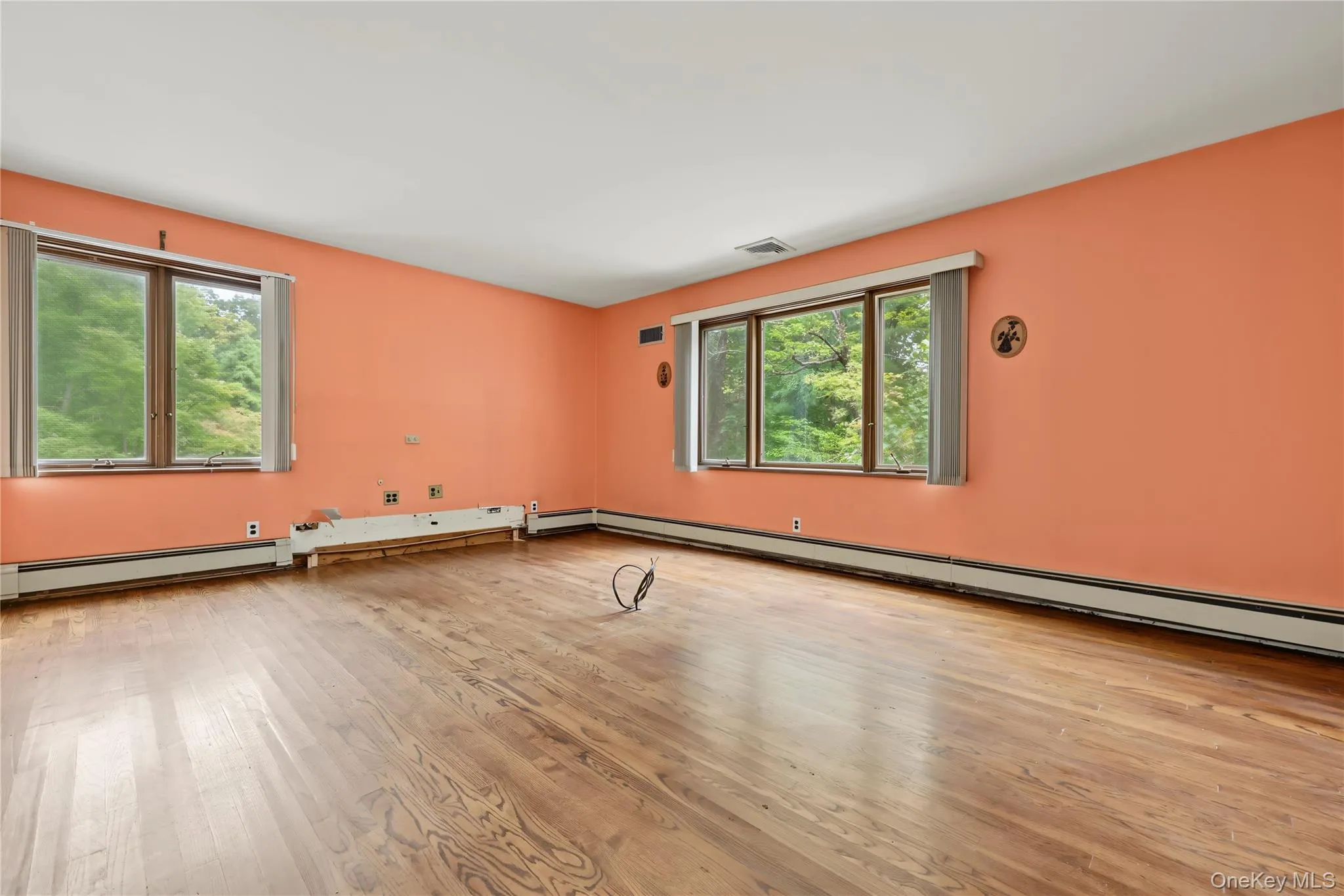 Large room with oversized windows and wood floors Large room with oversized windows and wood floors