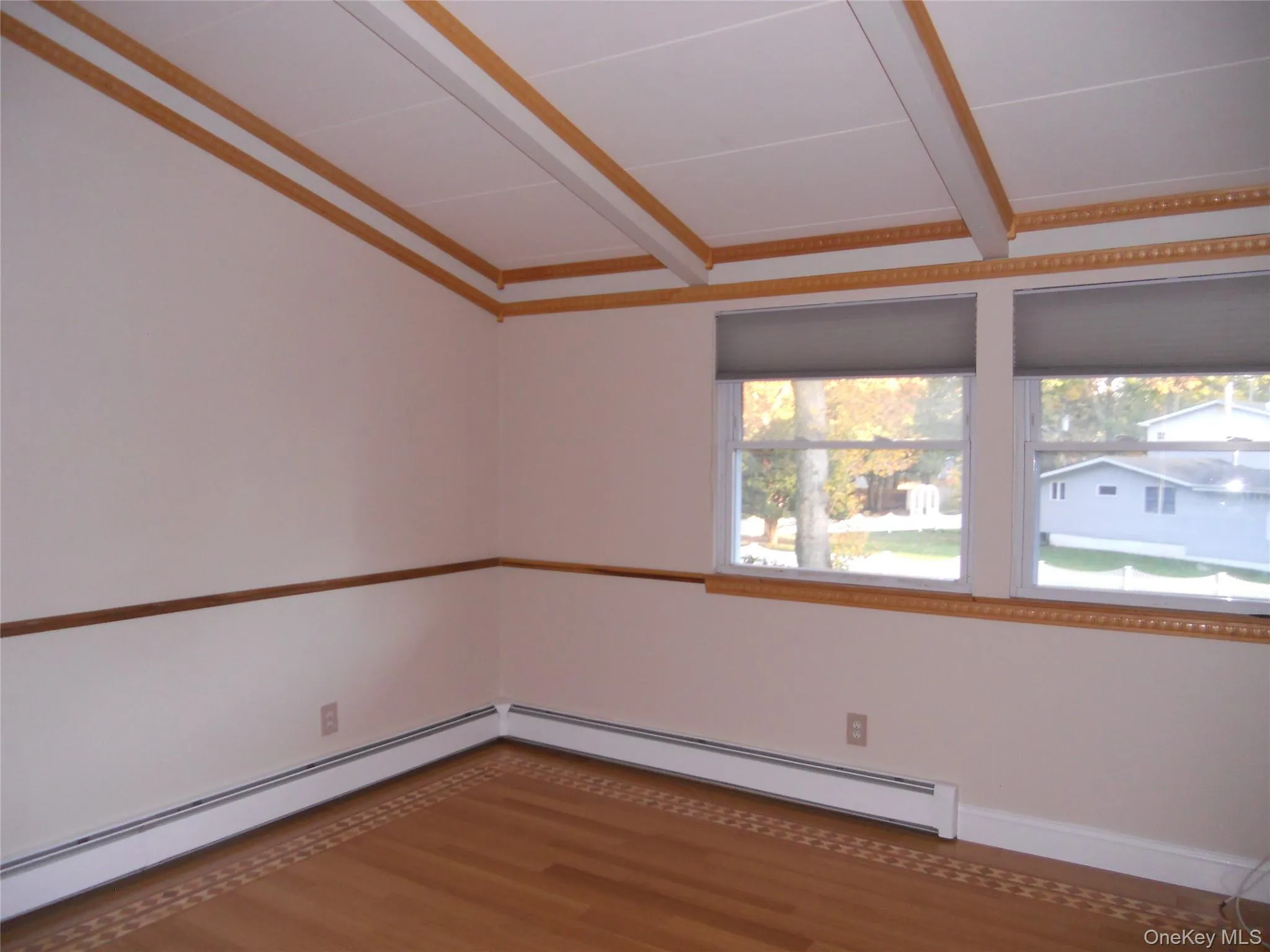 Wood-finish flooring with decorative inlay, two windows, and crown molding Wood-finish flooring with decorative inlay, two windows, and crown molding