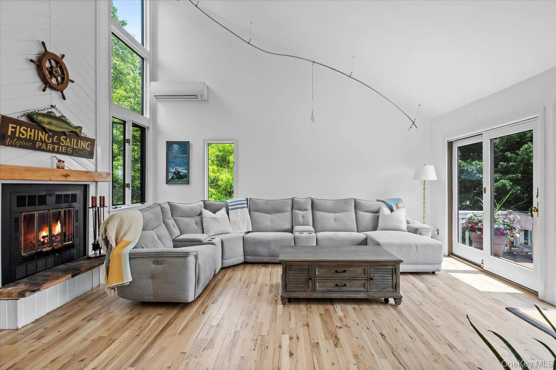 Living room featuring wood-type flooring, a glass covered fireplace, and healthy amount of natural light Living room featuring wood-type flooring, a glass covered fireplace, and healthy amount of natural light