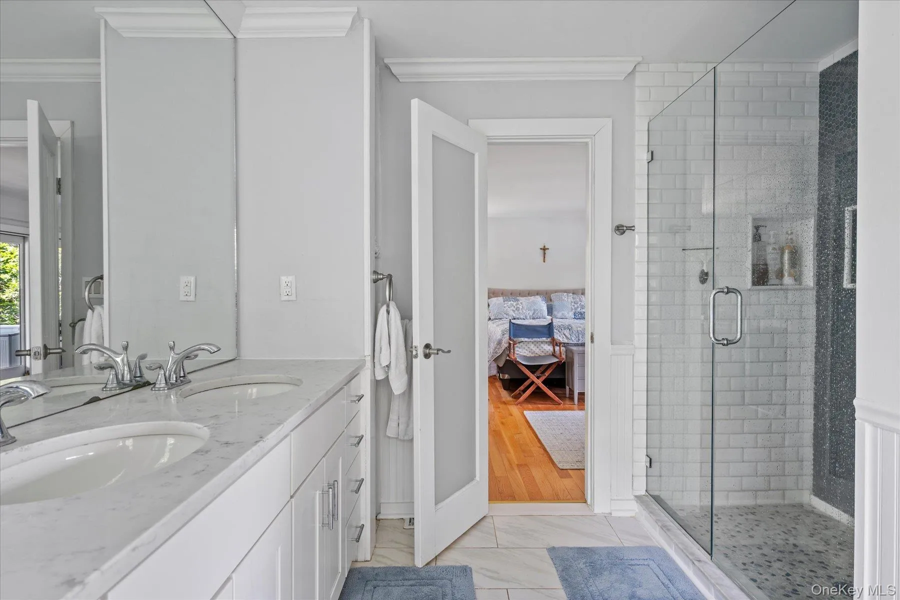Full bathroom with connected bathroom, double vanity, a stall shower, and crown molding Full bathroom with connected bathroom, double vanity, a stall shower, and crown molding