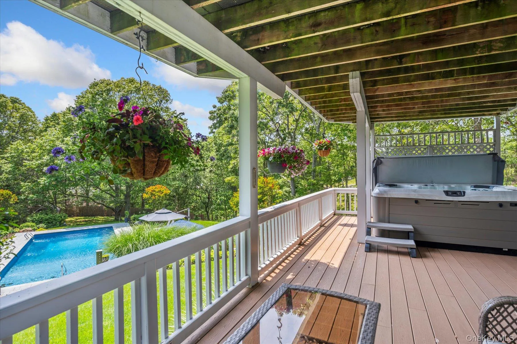 Wooden deck with a hot tub and an outdoor pool Wooden deck with a hot tub and an outdoor pool