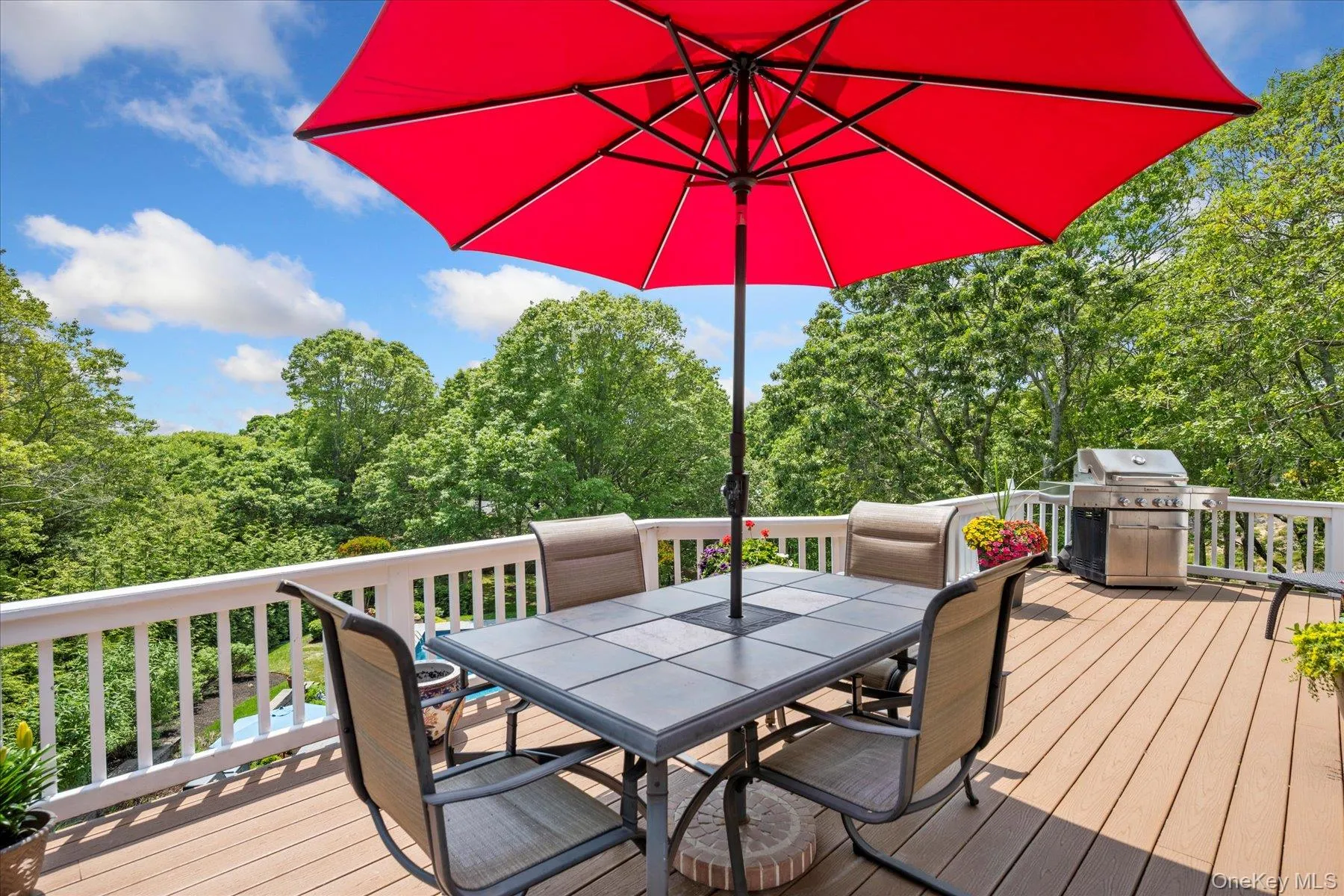 Wooden terrace featuring outdoor dining area and a grill Wooden terrace featuring outdoor dining area and a grill