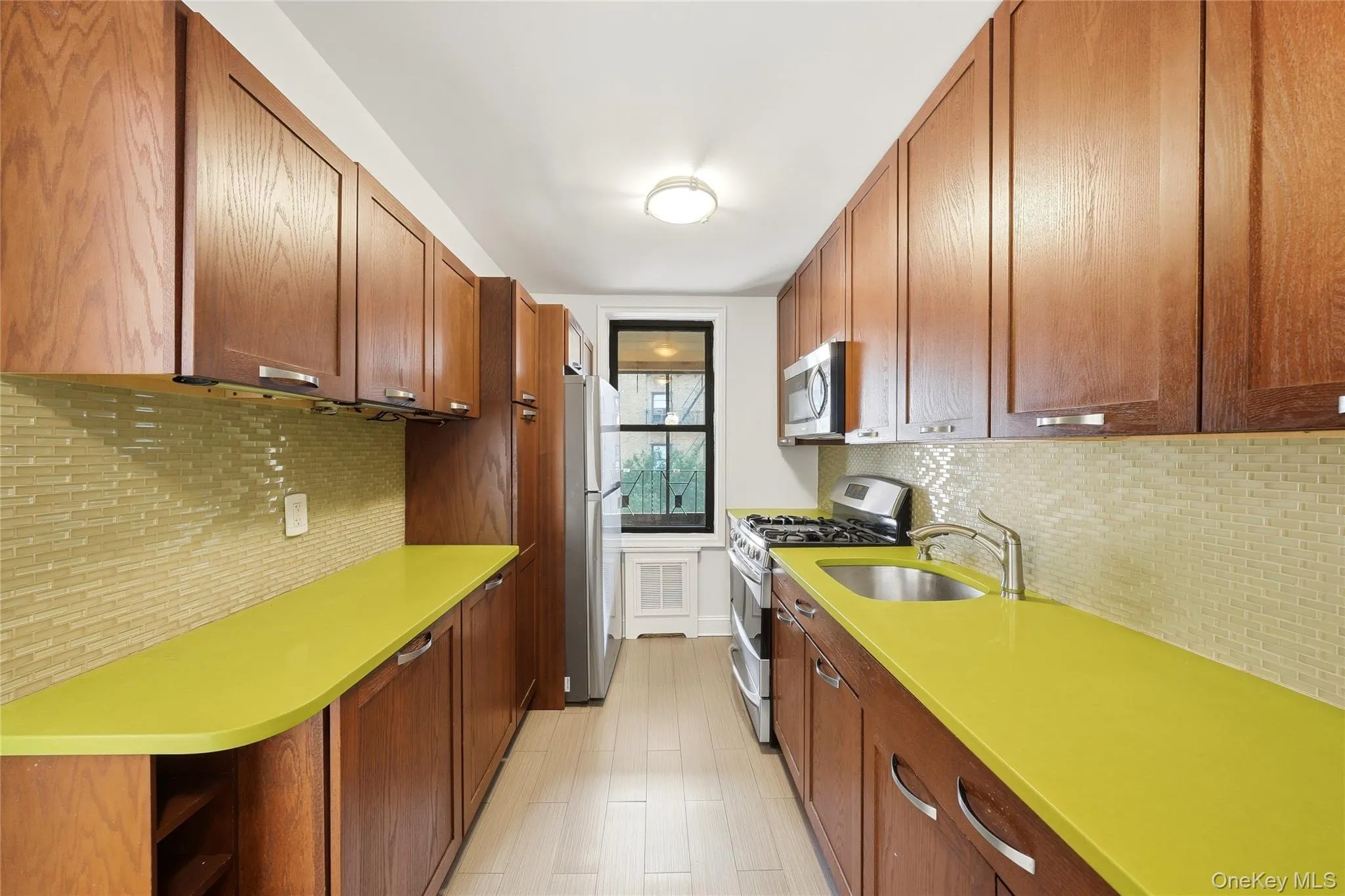 Windowed galley kitchen with multiple wooden cabinets Windowed galley kitchen with multiple wooden cabinets