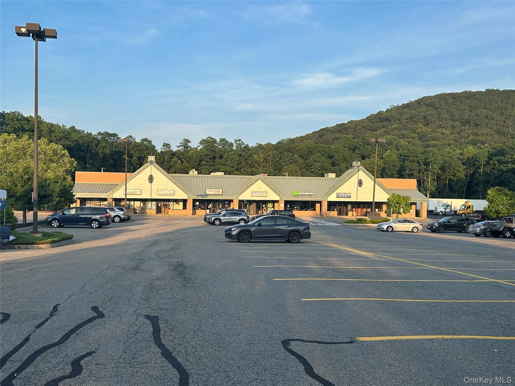 Uncovered parking lot featuring a view of trees Uncovered parking lot featuring a view of trees
