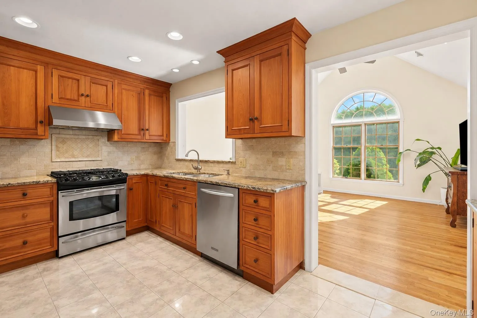 Kitchen includes stainless steel appliances and stone backsplash Kitchen includes stainless steel appliances and stone backsplash