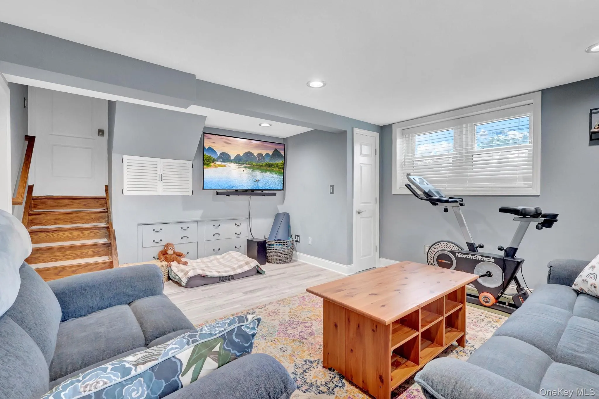 Finished lower level featuring recessed lighting, light wood-finish flooring, built-in cabinetry, and a window with blinds Finished lower level featuring recessed lighting, light wood-finish flooring, built-in cabinetry, and a window with blinds
