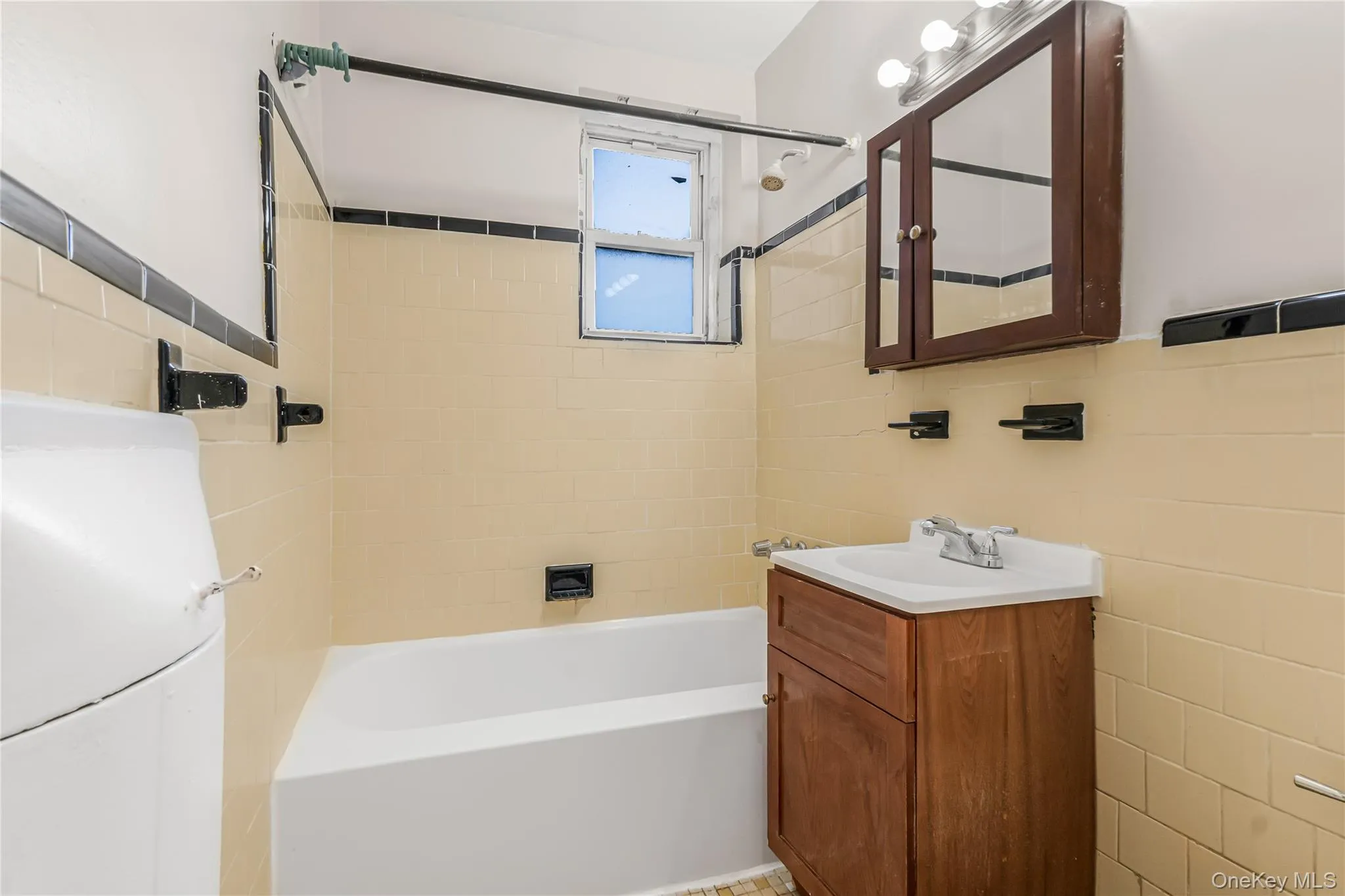 Bathroom with vanity, tile walls, and tub / shower combination Bathroom with vanity, tile walls, and tub / shower combination